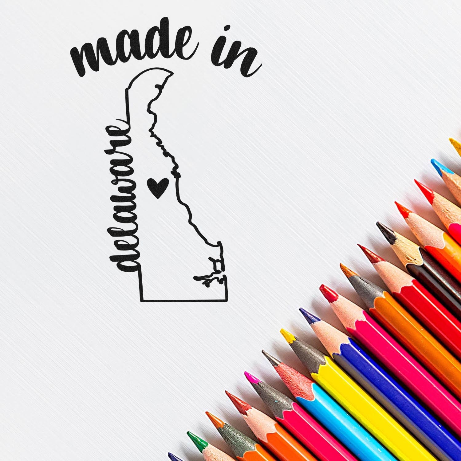 Self-Inking Handmade with Love in Delaware Stamp featuring a map outline with heart, surrounded by colorful pencils on a white background.