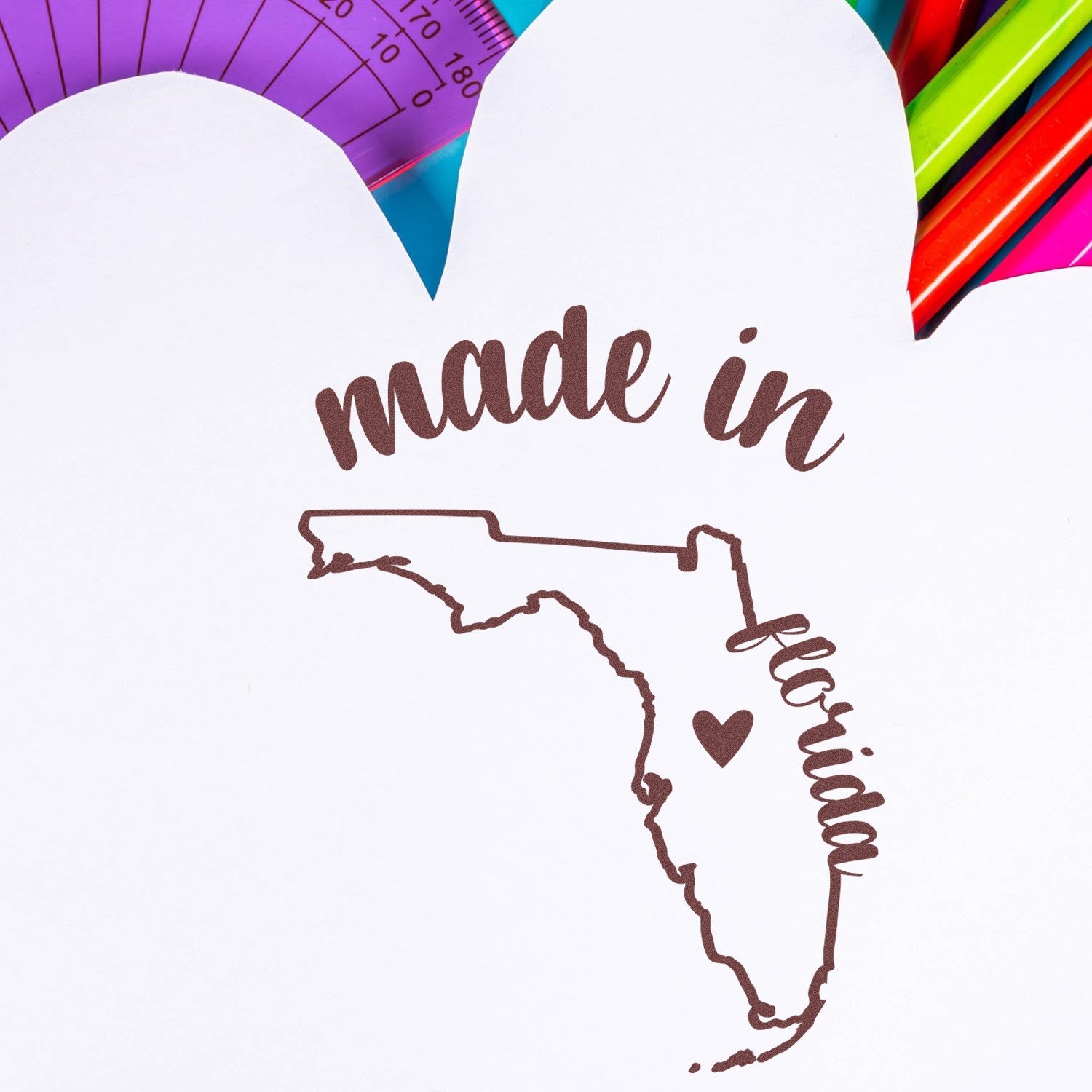 Made with Love in Florida Rubber Stamp featuring a heart and Florida outline, surrounded by colorful stationery. Perfect for crafts and personalized projects.