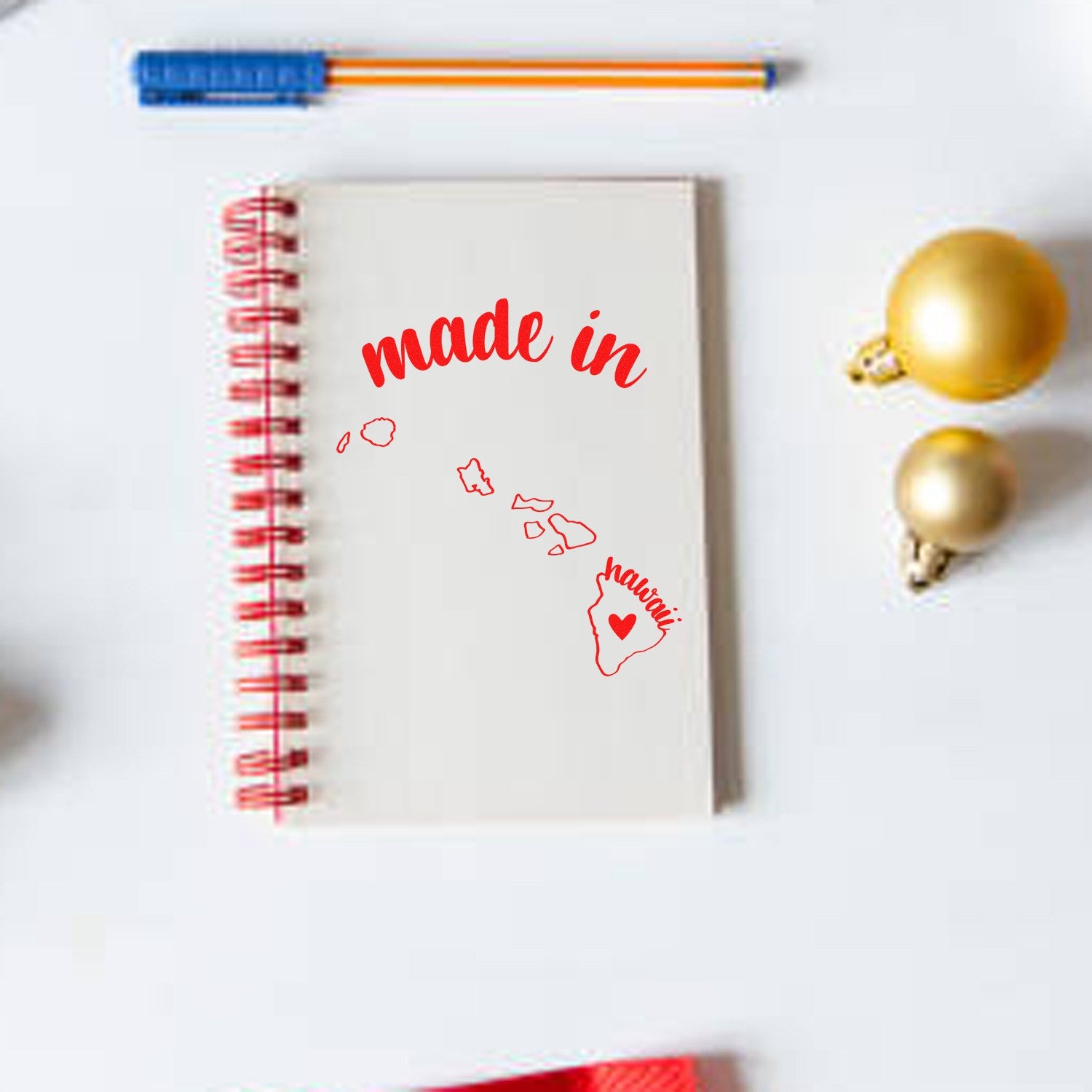 Made with Love in Hawaii Rubber Stamp on a notebook, featuring red text and a heart design with Hawaiian islands. Perfect for adding a personal touch to crafts and stationery.