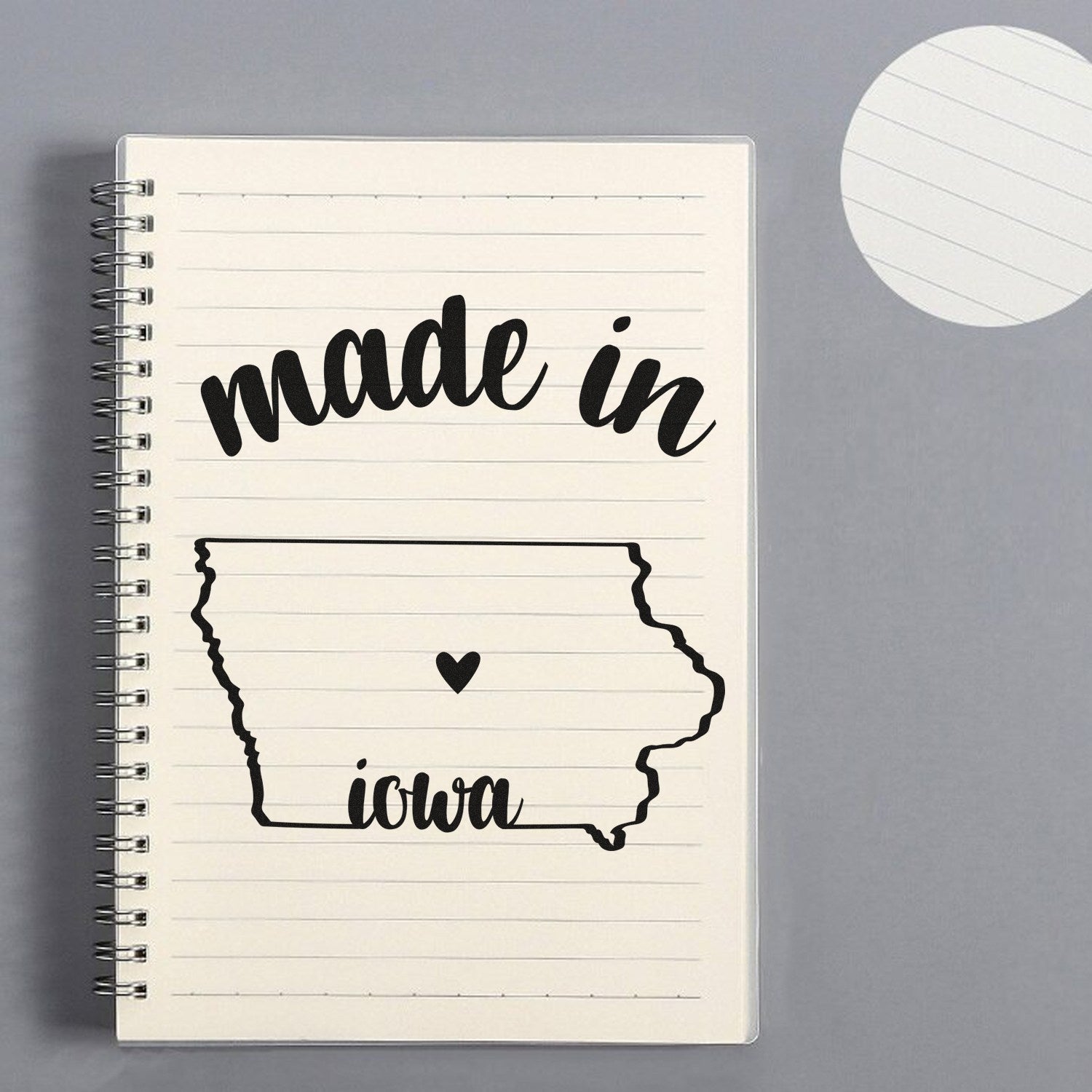 Slim Pre-Inked Stamp Iowa Made in Stamp on a lined notebook, featuring 'made in Iowa' with a heart inside the state outline. Perfect for adding a personal touch to stationery.