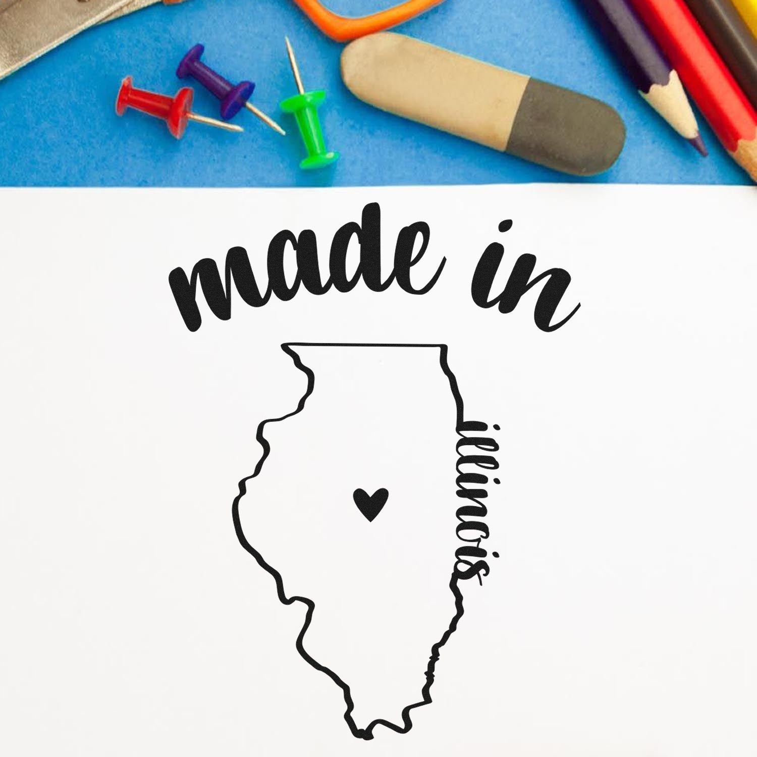 Made with Love in Illinois Rubber Stamp featuring a heart inside the state outline, surrounded by colorful stationery on a blue background.