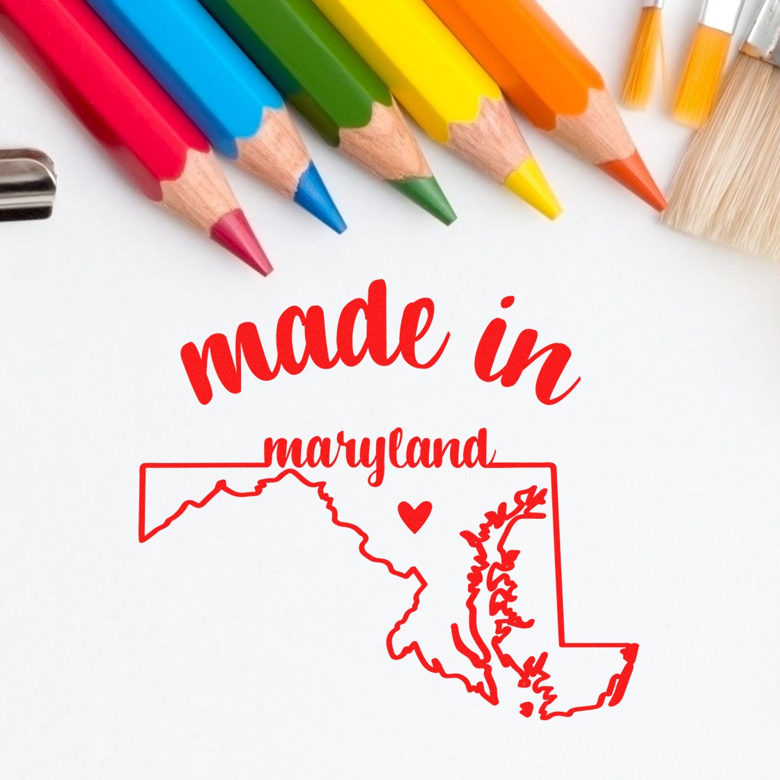 Made with Love in Maryland Rubber Stamp featuring red text and a heart within the Maryland state outline, surrounded by colorful pencils and a paintbrush.