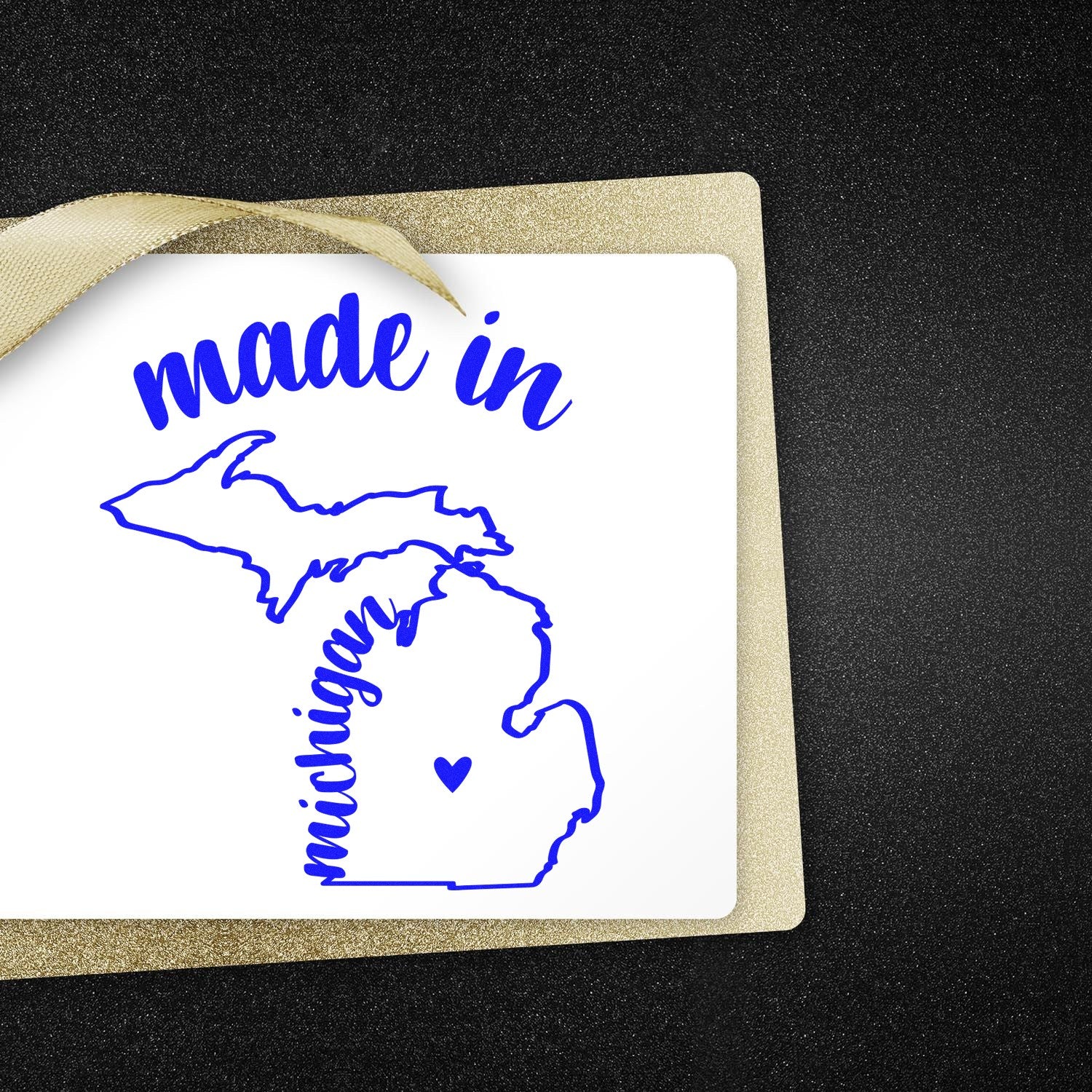 Slim Pre-Inked Stamp Michigan Made in Stamp featuring a blue outline of Michigan with 'made in' text, perfect for crafts and gifts. Set against a black and gold background.