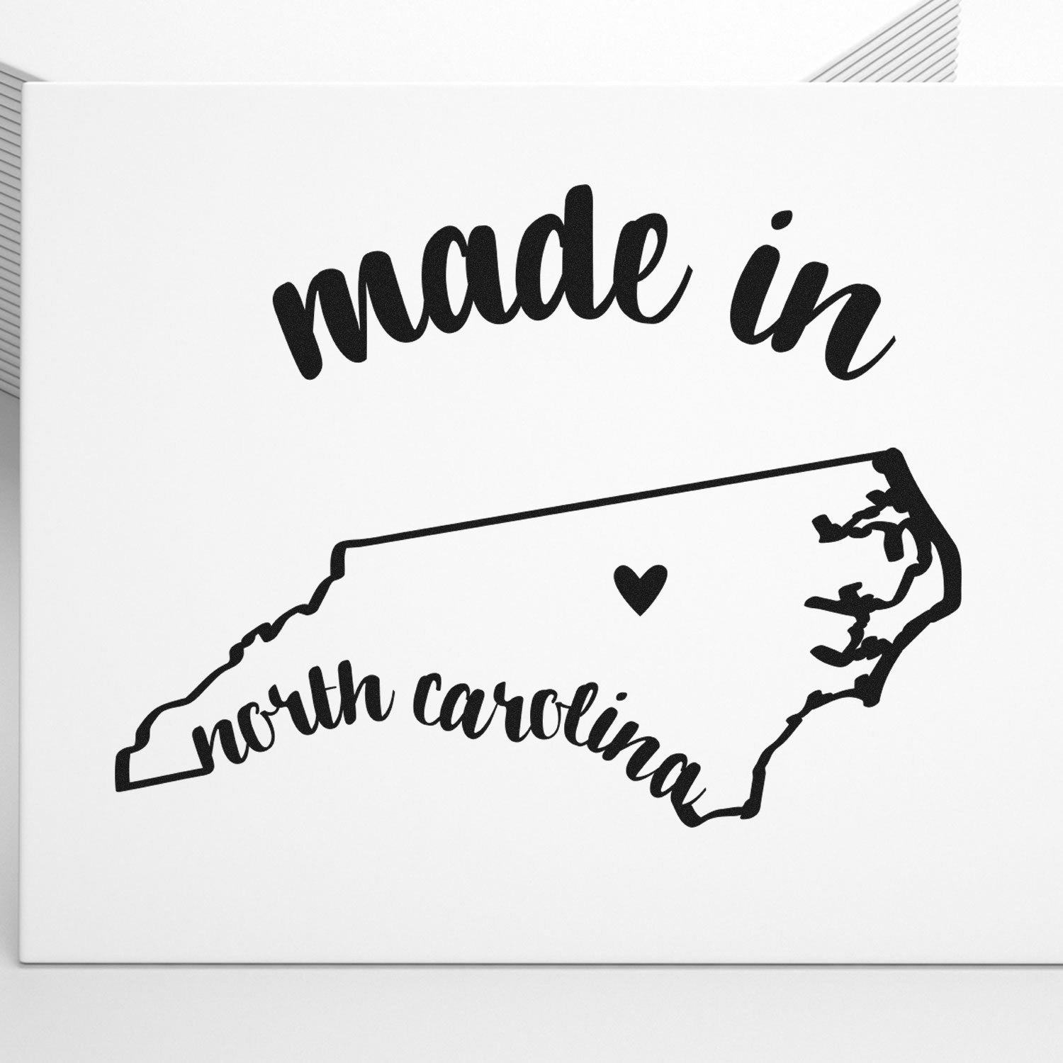 Made with Love in North Carolina Rubber Stamp featuring a heart and state outline, perfect for crafts and gifts. Black ink design on a white background.