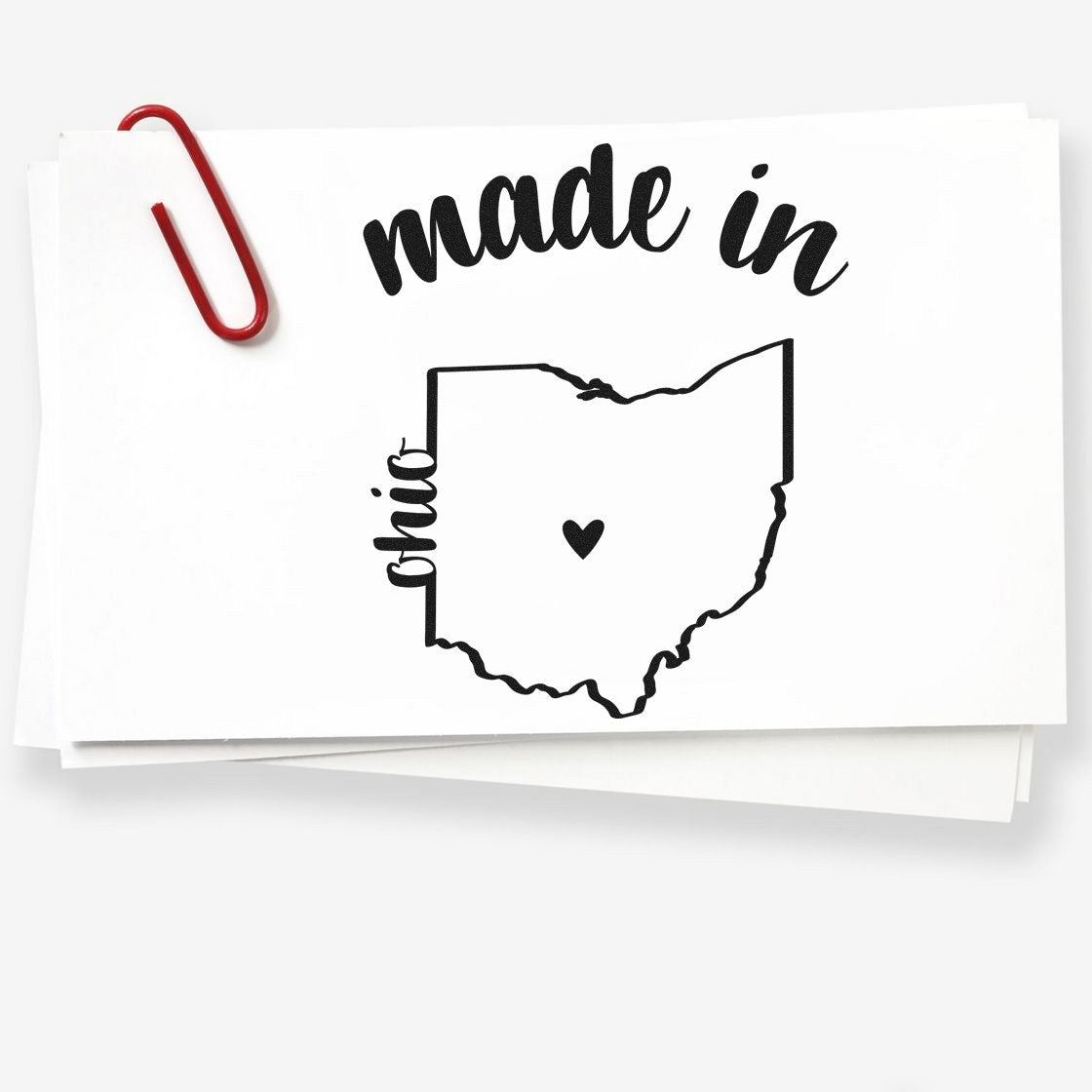 Slim Pre-Inked Stamp Ohio Made in Stamp featuring Ohio outline with heart, black ink on white paper, red paperclip attached.