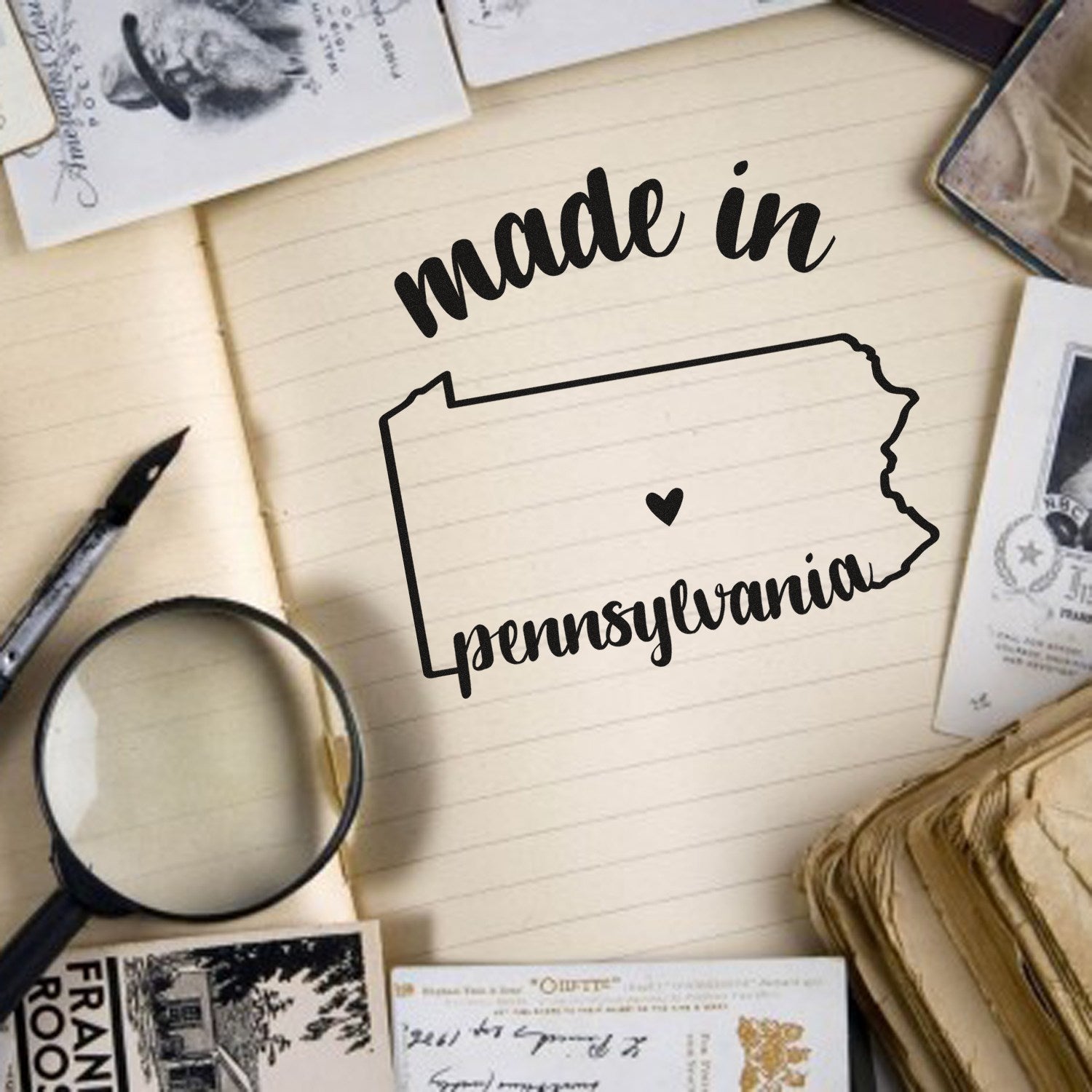 Made with Love in Pennsylvania Rubber Stamp on vintage paper background, featuring state outline and heart design, surrounded by old photos and a magnifying glass.