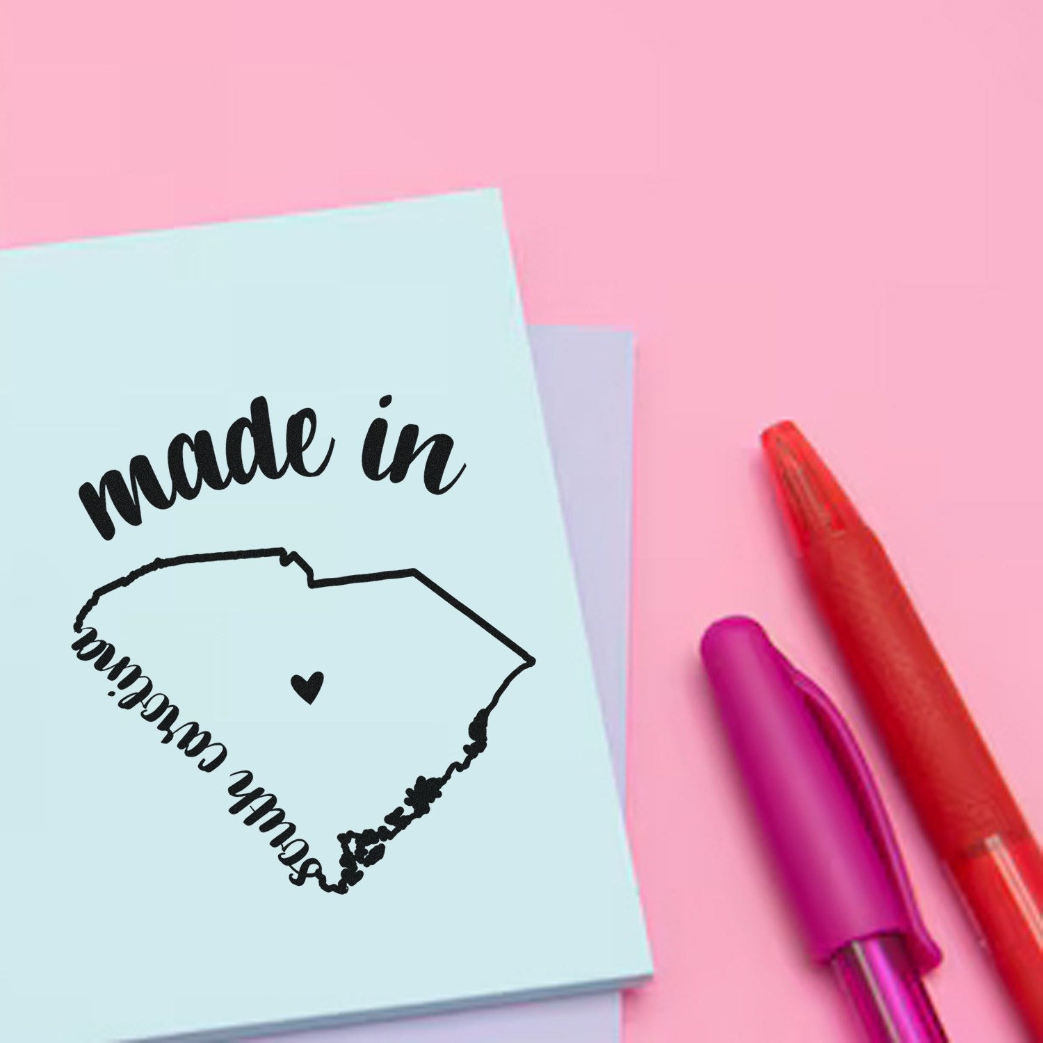 Made with Love in South Carolina Rubber Stamp on pastel paper with pink and red pens, featuring a heart and state outline design. Perfect for crafts and personalized projects.