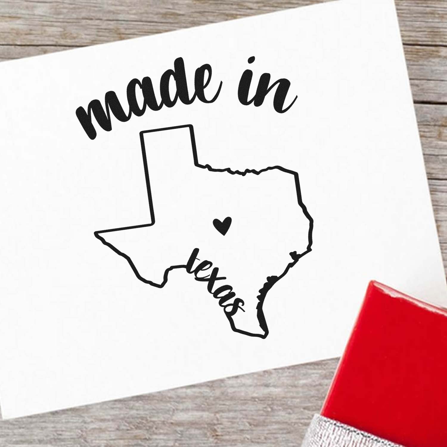 Made in Texas Stamp Pre-Inked: Black outline of Texas with heart, 'made in' text above, 'Texas' below, on white paper. Red stamp corner visible. Perfect for crafts and branding.