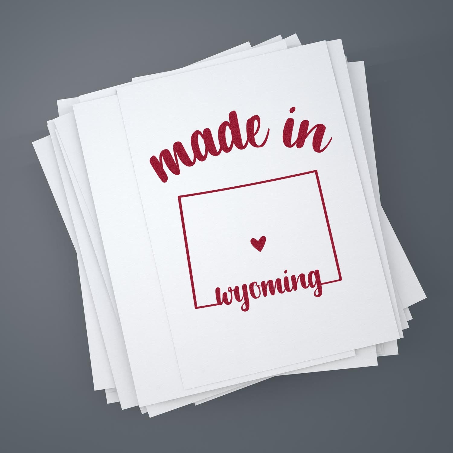 Self-Inking Handmade with Love in Wyoming Stamp on paper stack, featuring red text and heart design, perfect for crafts and gifts.