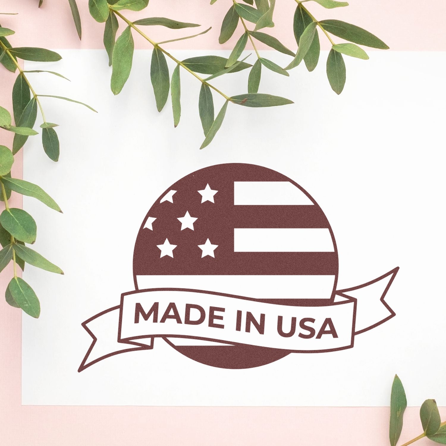 Self-Inking Patriot Seal Of Quality Stamp featuring a Made in USA design with stars and stripes, displayed on a white background with green leaves. Perfect for authenticating products.