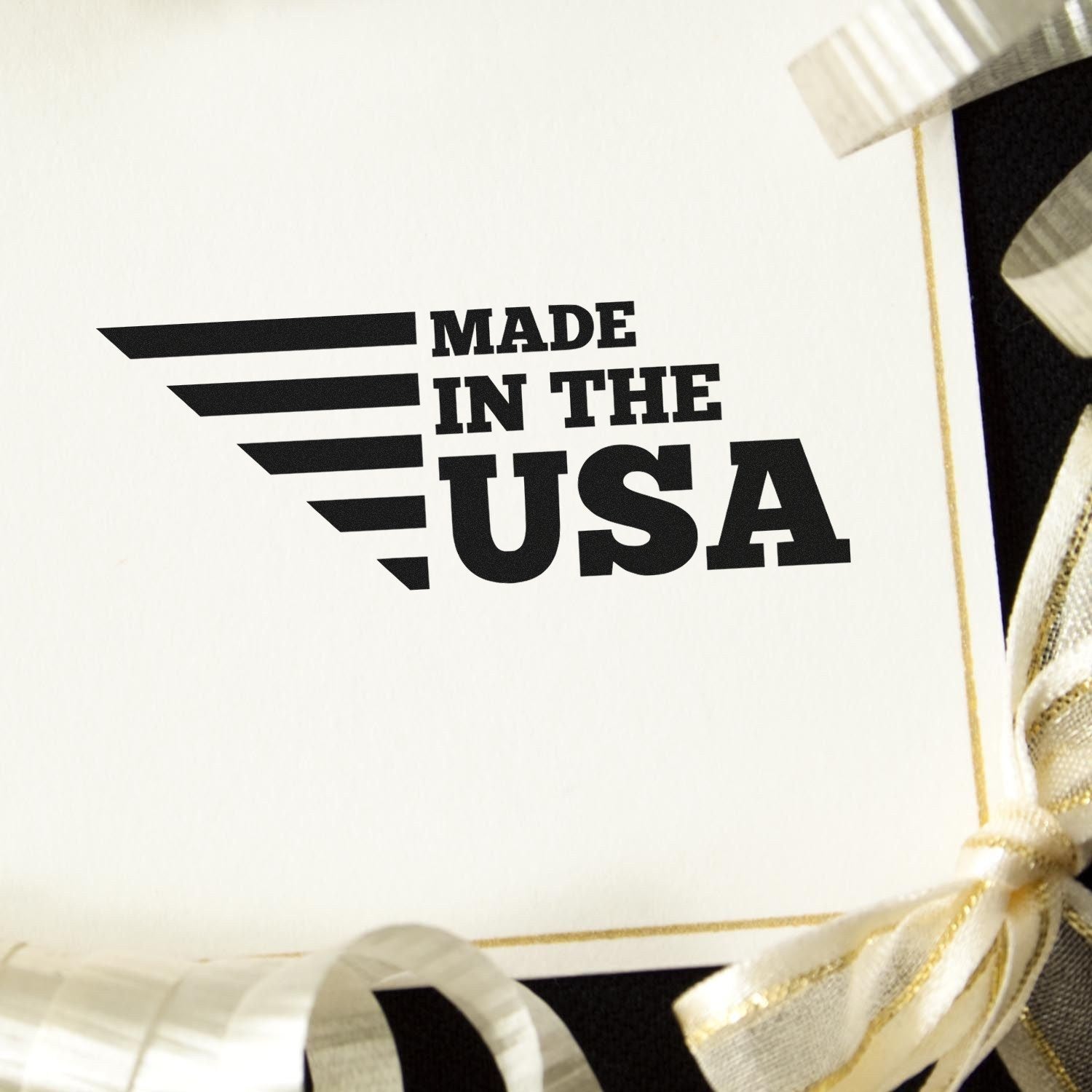 Slim Pre-Inked Patriotic and Proud Stamp displaying Made in the USA on a white card with gold ribbon accents. Perfect for adding a patriotic touch to your projects.