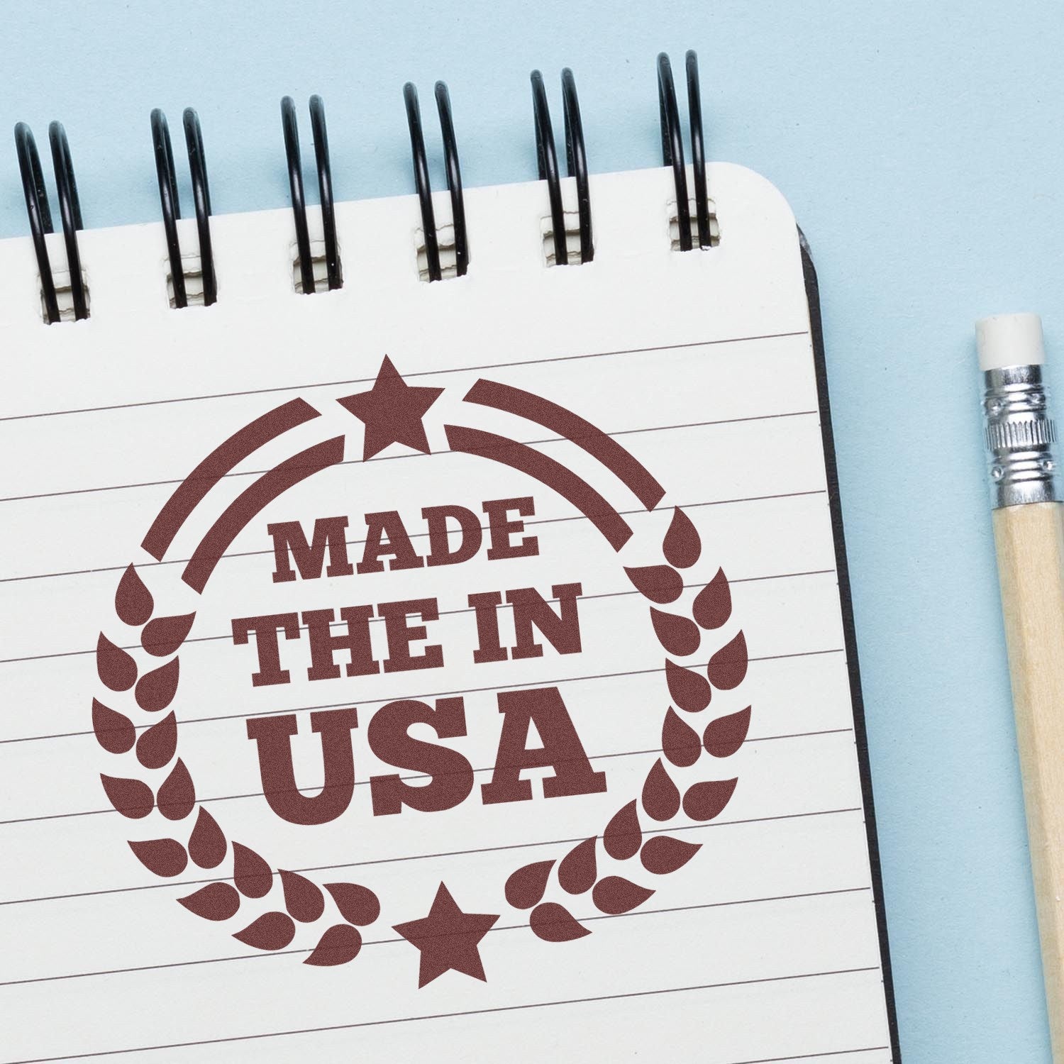 Image of the Slim Pre-Inked Made In The USA Proudly Stamp on a notepad, featuring a circular design with stars and laurel leaves, emphasizing American craftsmanship.