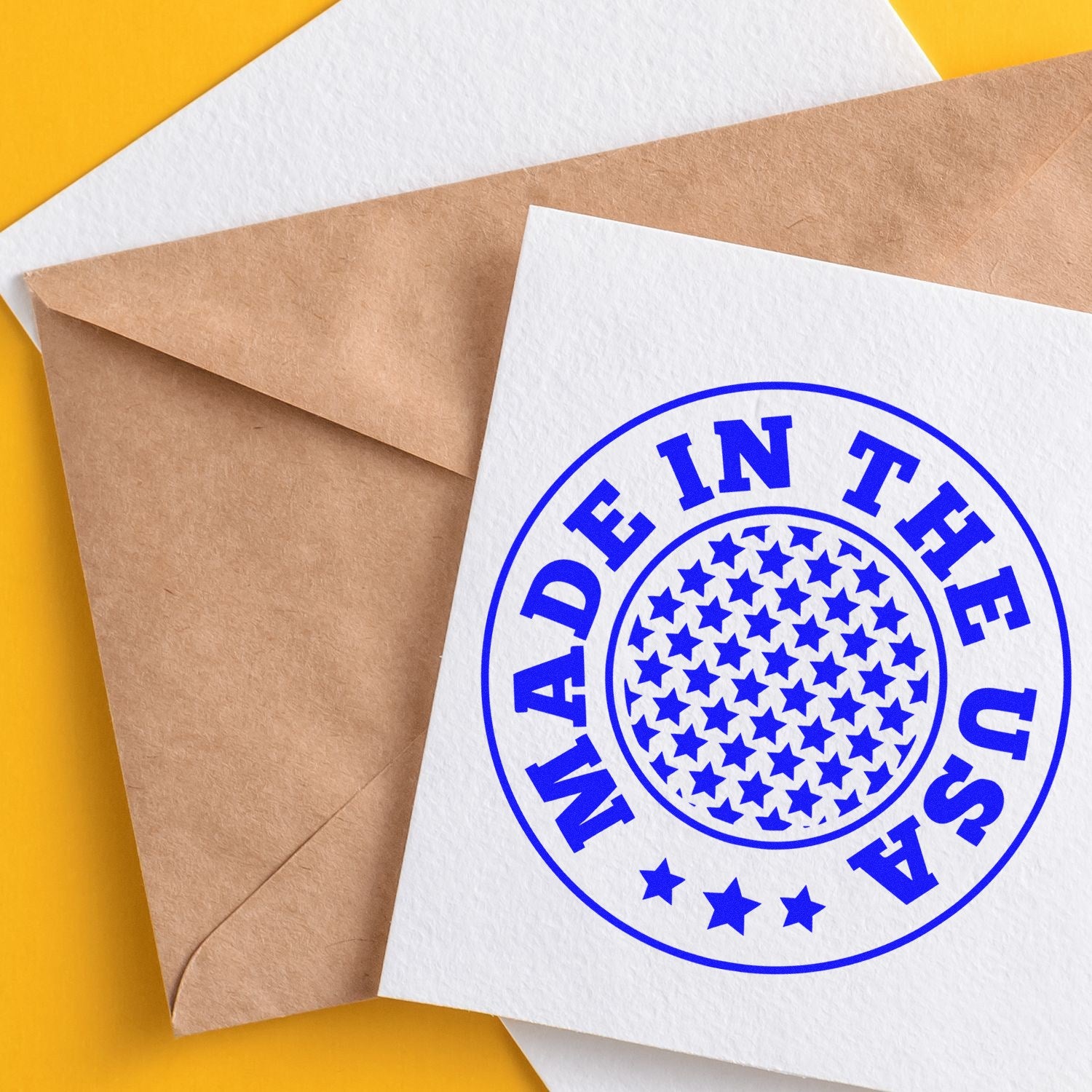 Wood Handle Stars Of America Rubber Stamp featuring a circular design with blue stars and Made in the USA text, shown on white paper with a brown envelope on a yellow background.