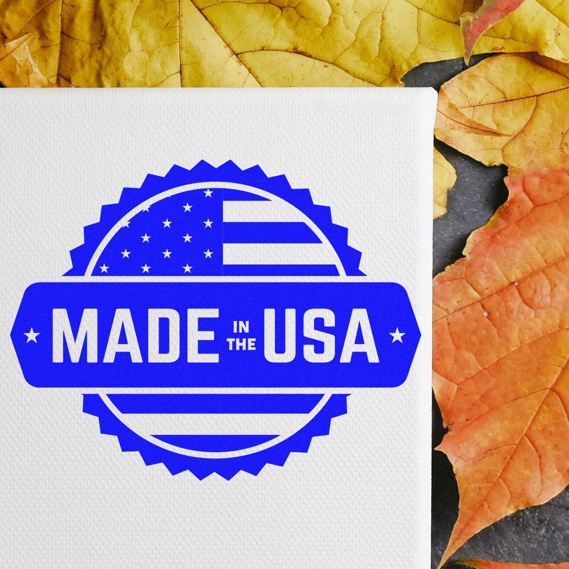 Wood Handle American Craftsmanship Seal Rubber Stamp on canvas with Made in the USA design, surrounded by autumn leaves. Perfect for adding a patriotic touch to crafts and projects.