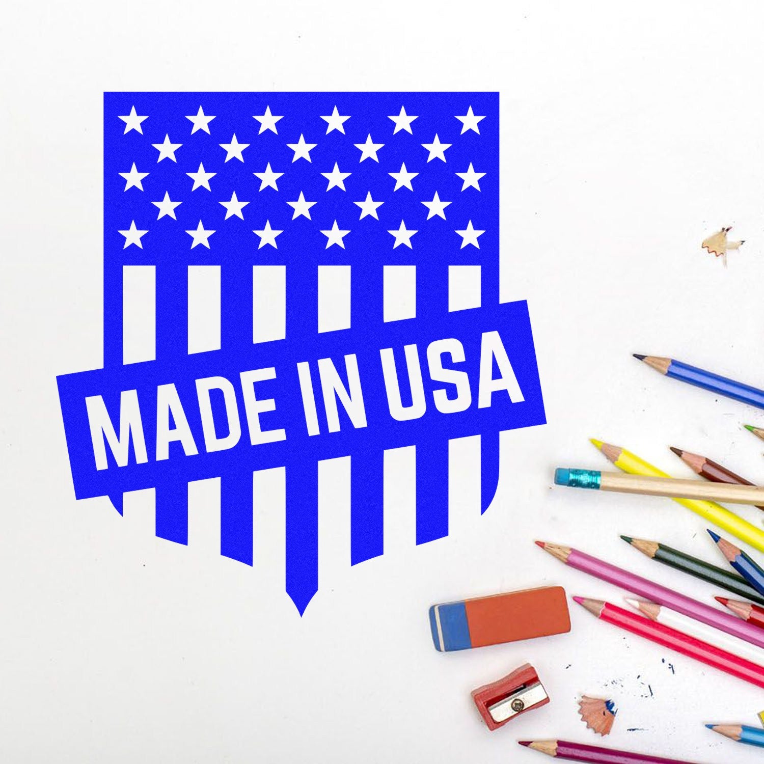 Slim Pre-Inked Patriotic Seal Of Quality Stamp featuring a blue Made in USA design with stars and stripes, surrounded by colorful pencils and erasers on a white background.