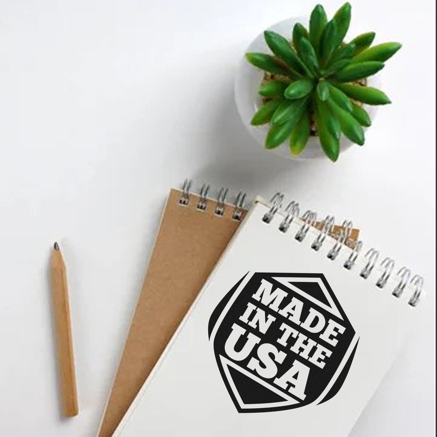 Wood Handle American Pride Seal Rubber Stamp on a notepad, featuring Made in the USA design, next to a pencil and a small potted plant on a white surface.