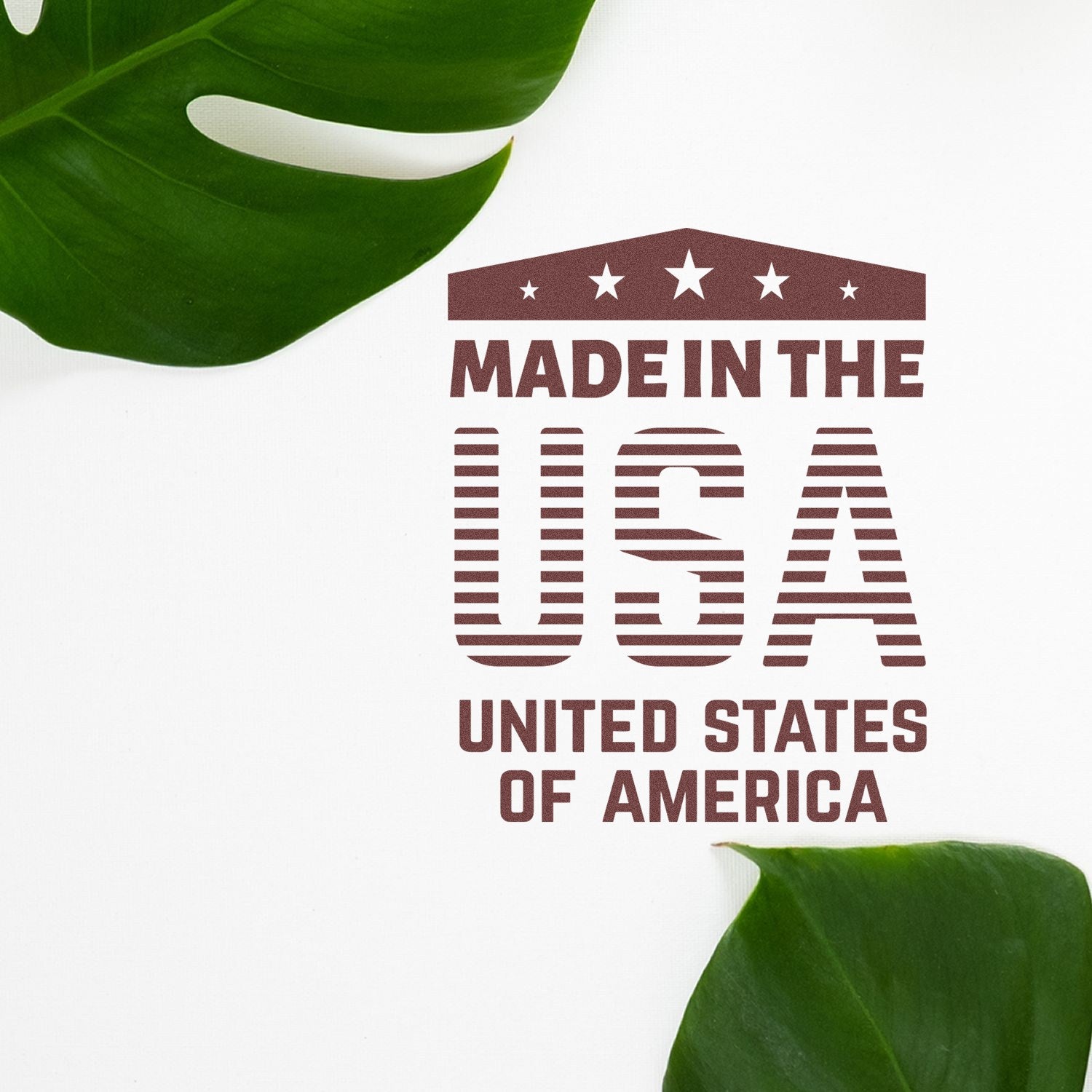 Self-Inking Patriotic Pride Stamp with 'Made in the USA' design, featuring stars and stripes, surrounded by green leaves on a white background.