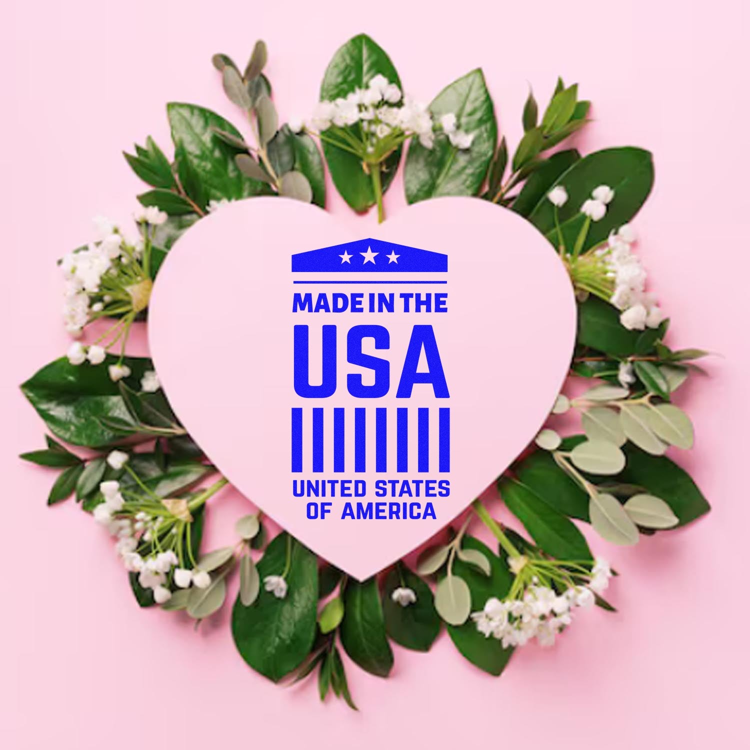 Self-Inking American Pride Emblem Stamp on a pink heart surrounded by green leaves and white flowers, featuring Made in the USA text in blue. Perfect for patriotic crafts and documents.