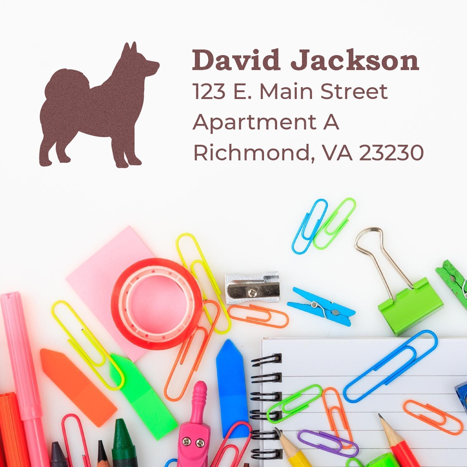 Self-Inking Alaskan Malamute Dog Address Stamp on paper with colorful stationery items like paper clips, pens, and sticky notes.