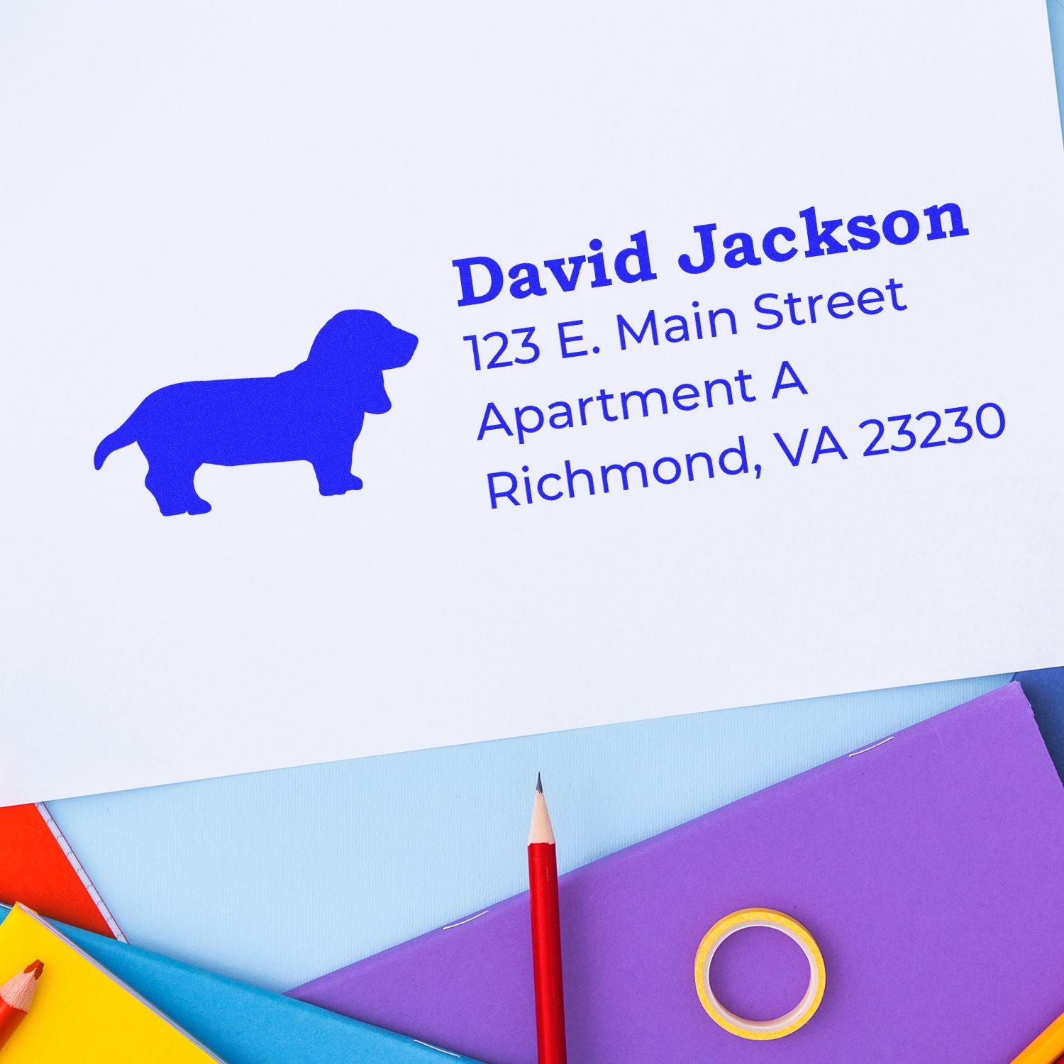 Basset Hound Silhouette Address Rubber Stamp on white paper with colorful stationery. Blue silhouette of a Basset Hound next to address text in bold font.