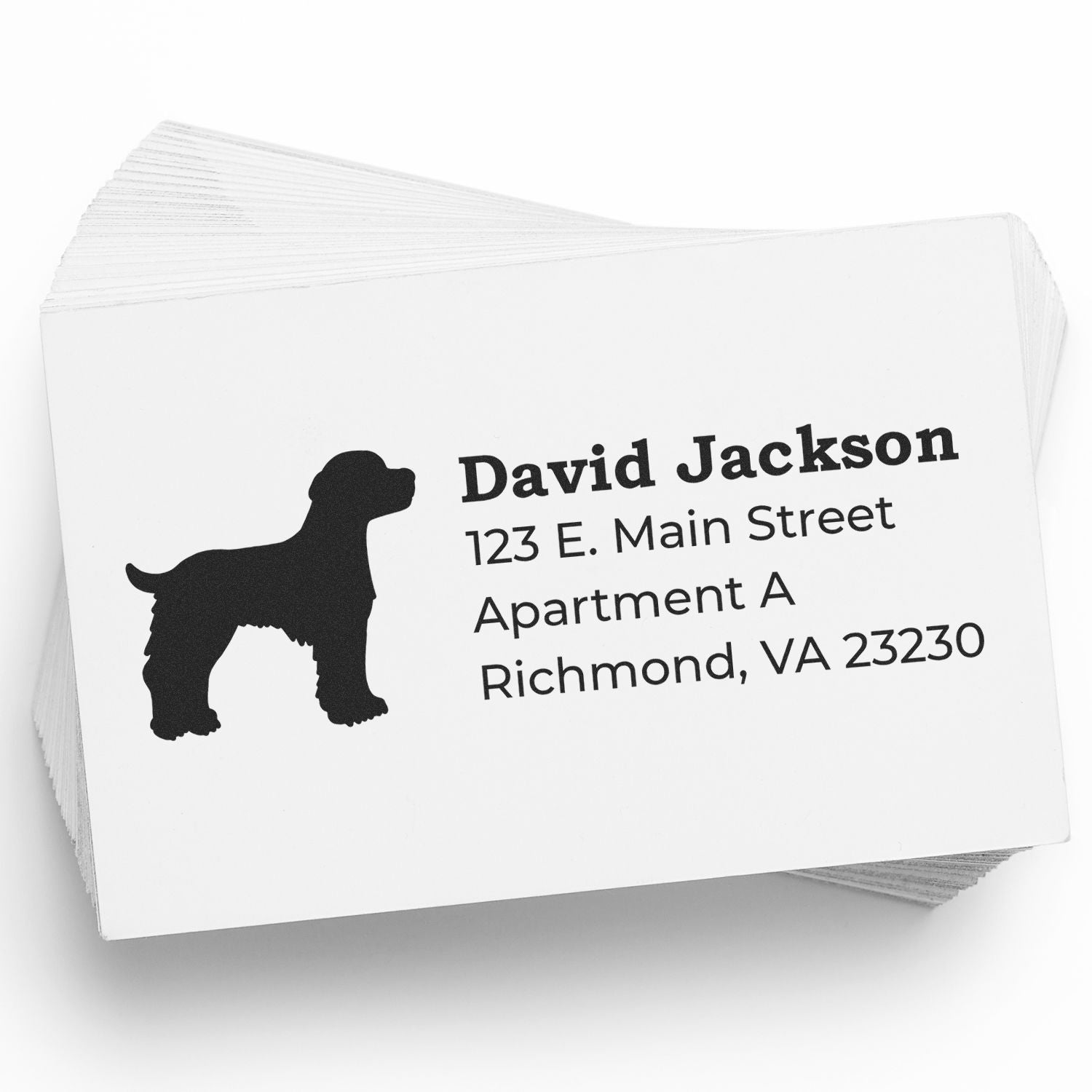 Stack of cards featuring the Slim Pre-Inked Brittany Spaniel Address Stamp with a silhouette of a dog and sample address text. Perfect for personalized mailings.