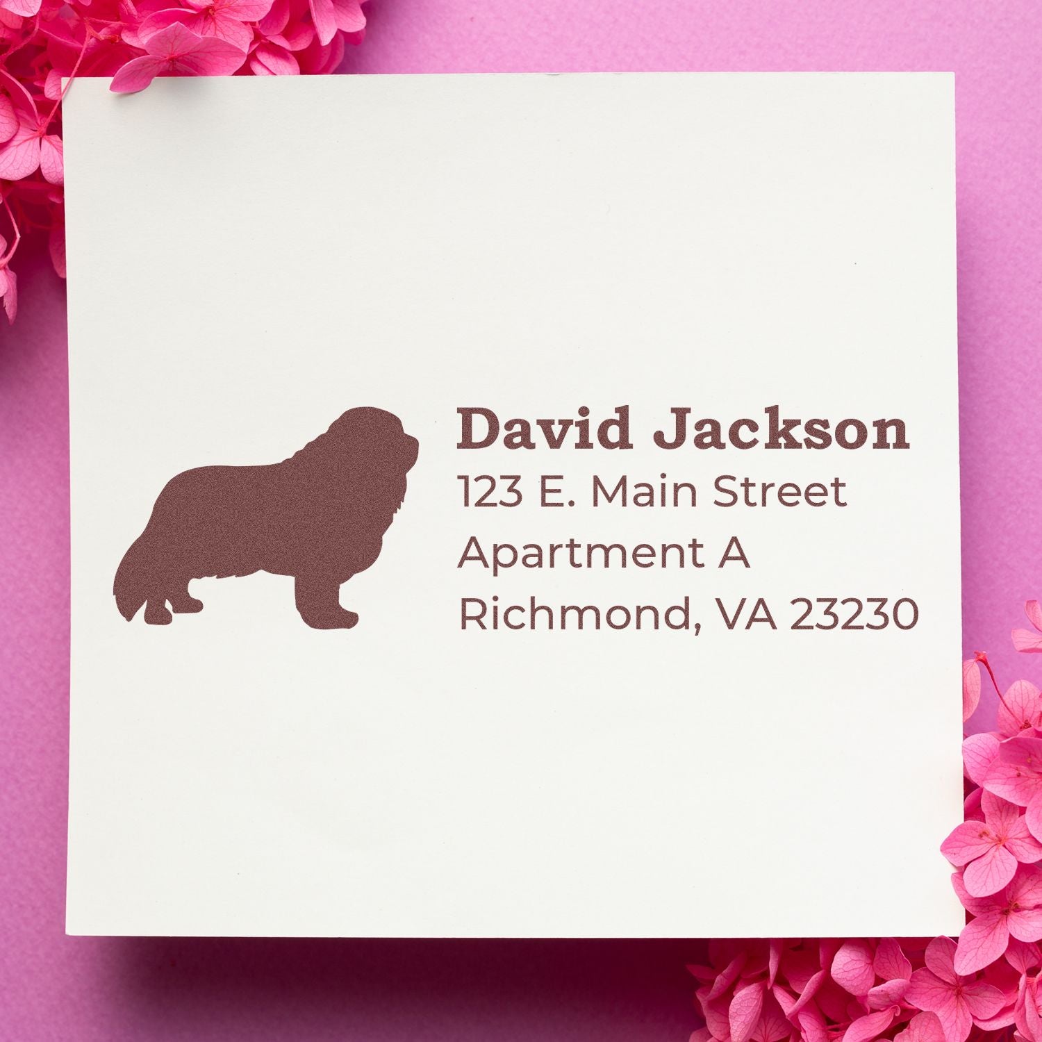 Self-Inking Cavalier King Charles Dog Address Stamp on white paper with a silhouette of the dog, surrounded by pink flowers. Text includes a sample address in elegant font.