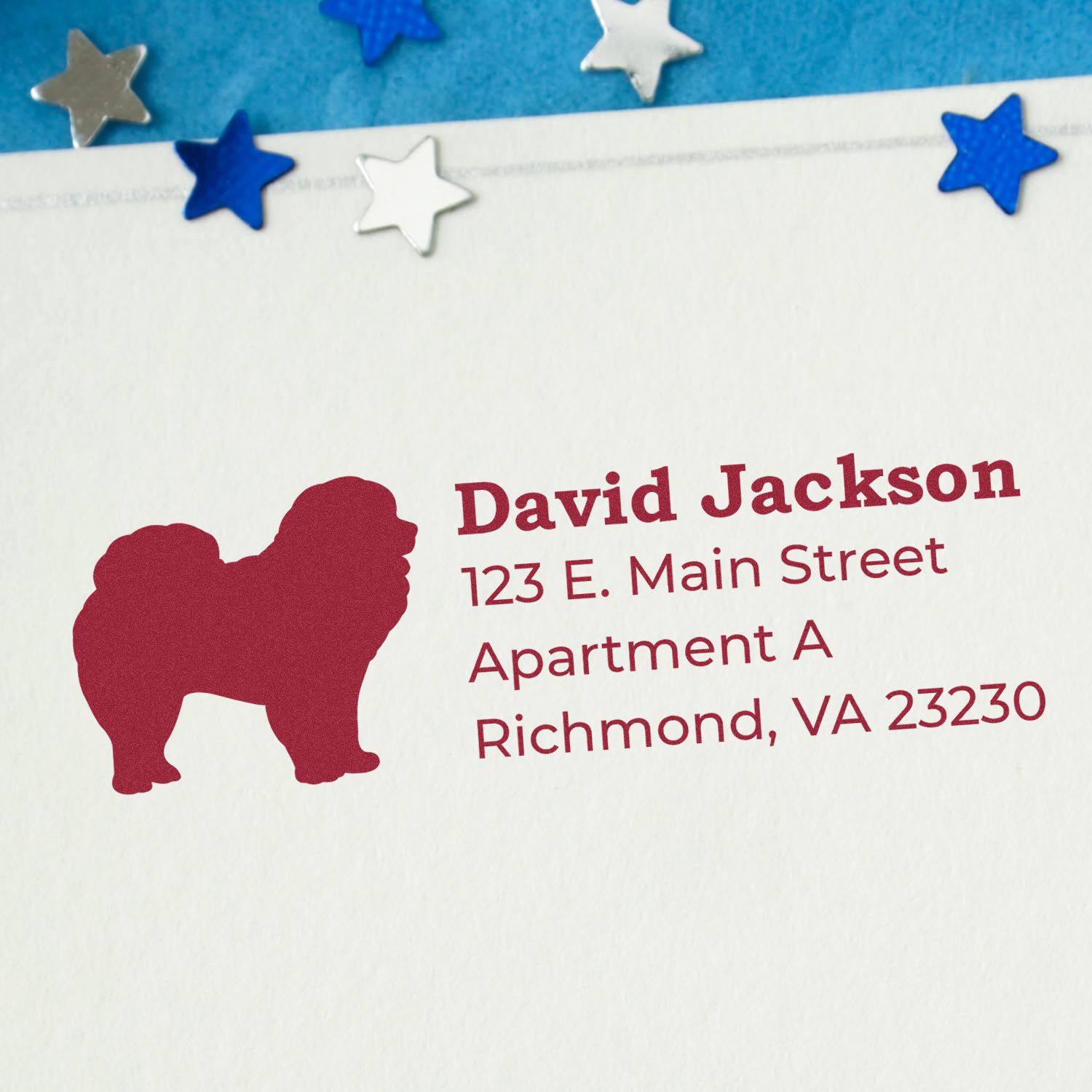 Chow Silhouette Address Rubber Stamp on an envelope, featuring a red Chow Chow silhouette and sample address text. Blue and silver star decorations are visible in the background.