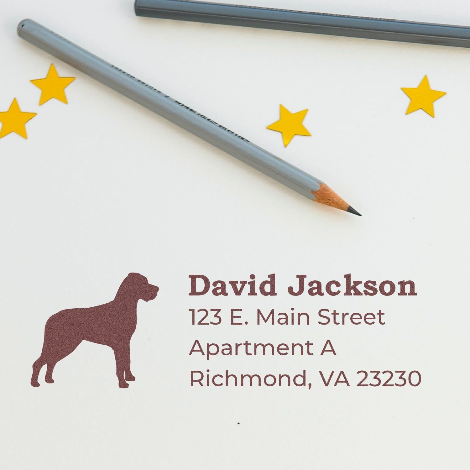 PSI Pre-Inked Personalized Great Dane Address Stamp on white paper with a Great Dane silhouette, address details, and two gray pencils nearby.