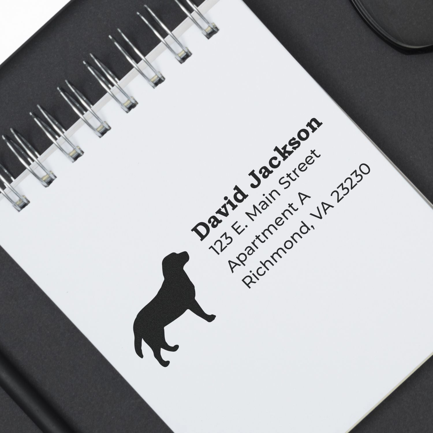 Labrador Silhouette Address Rubber Stamp on a notepad, featuring a black Labrador silhouette above a sample address. Perfect for personalizing mail with a touch of canine charm.