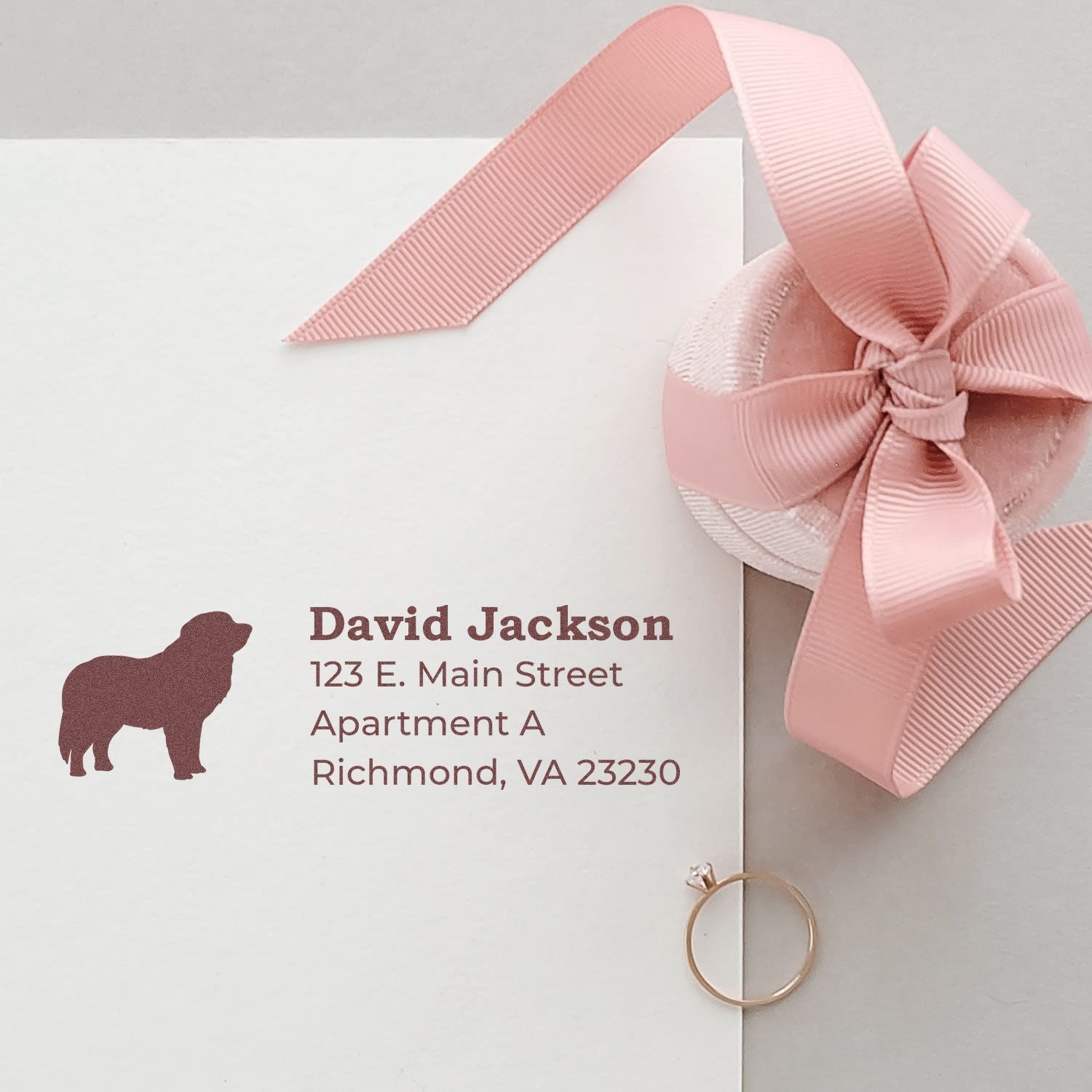 Self-Inking Pyrenees Dog Address Stamp on an envelope with a pink ribbon and ring, showcasing a silhouette of a Pyrenees dog next to the address text.