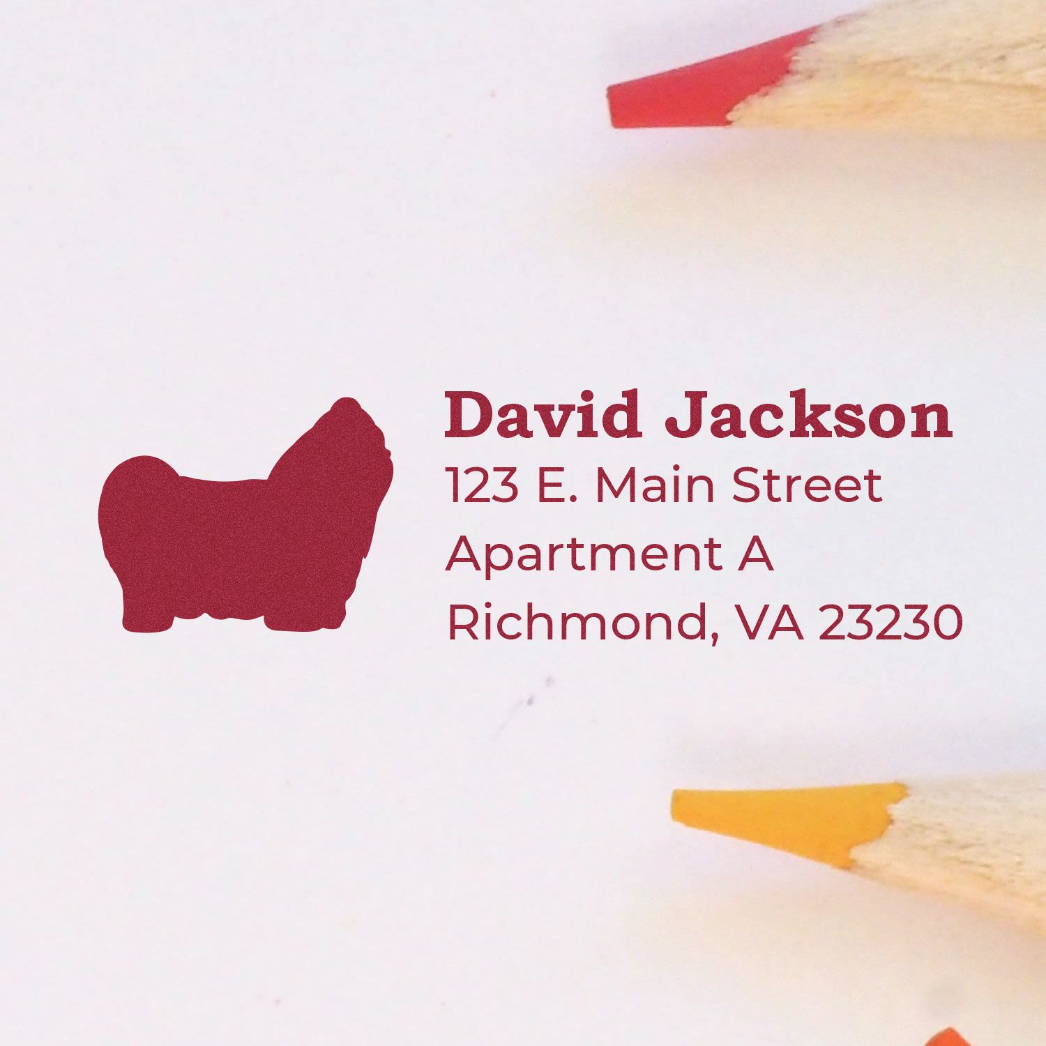 Self-Inking Shih Tzu Dog Address Stamp imprint on paper with red silhouette of a Shih Tzu, next to sharpened red and yellow pencils.