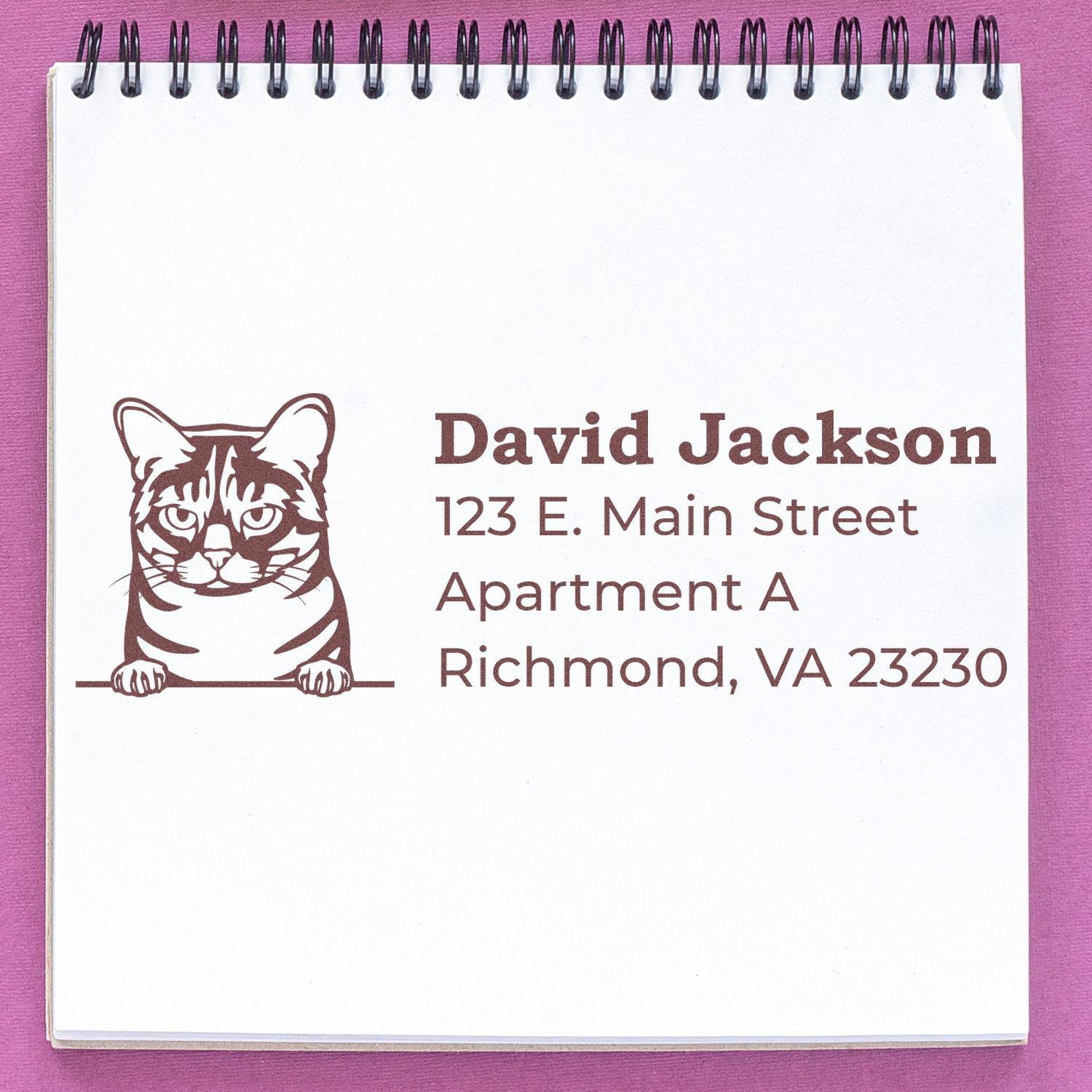 Self-Inking Australian Mist Custom Address Stamp on a notepad, featuring a cat illustration and sample address text in brown ink.