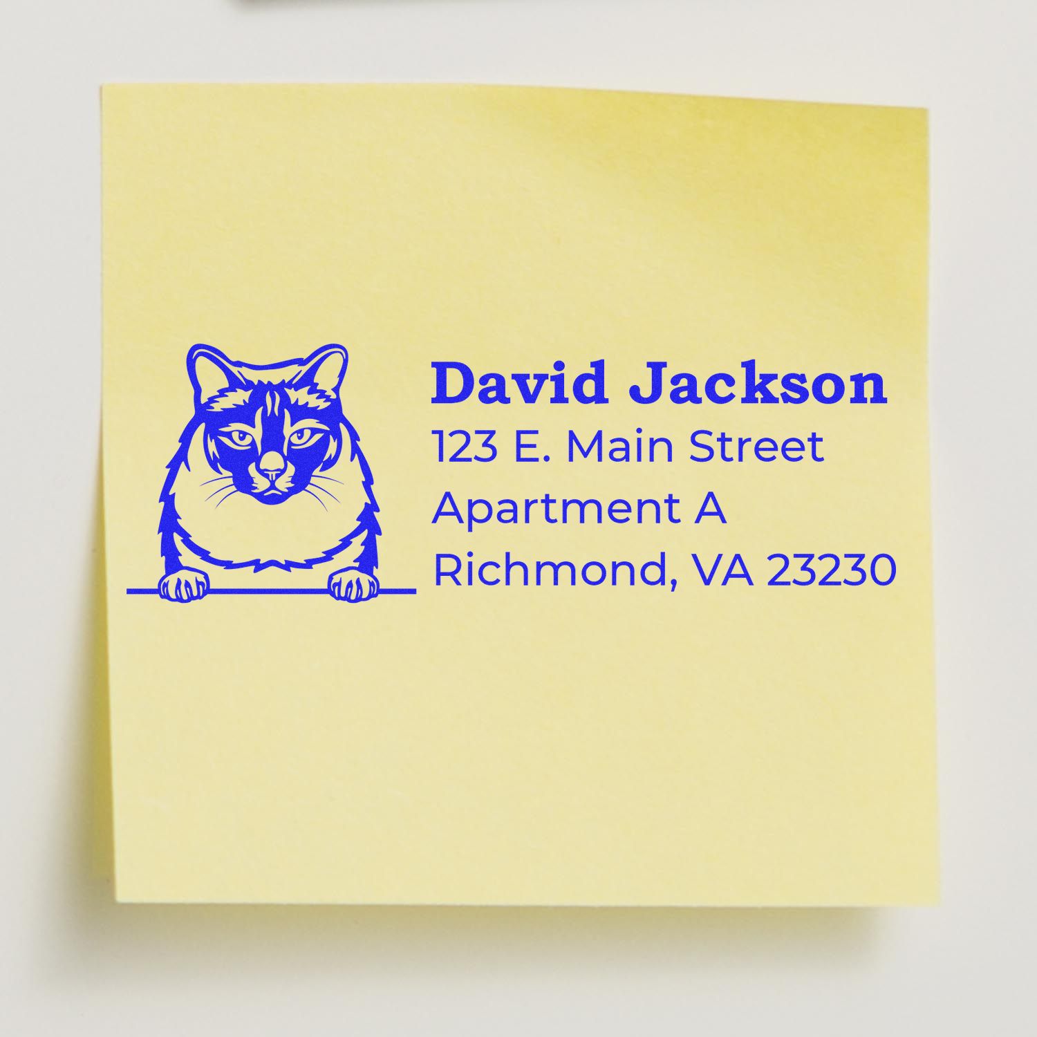 Yellow sticky note with blue inked cat design and address details, stamped using the Self-Inking Balinese Custom Address Stamp.