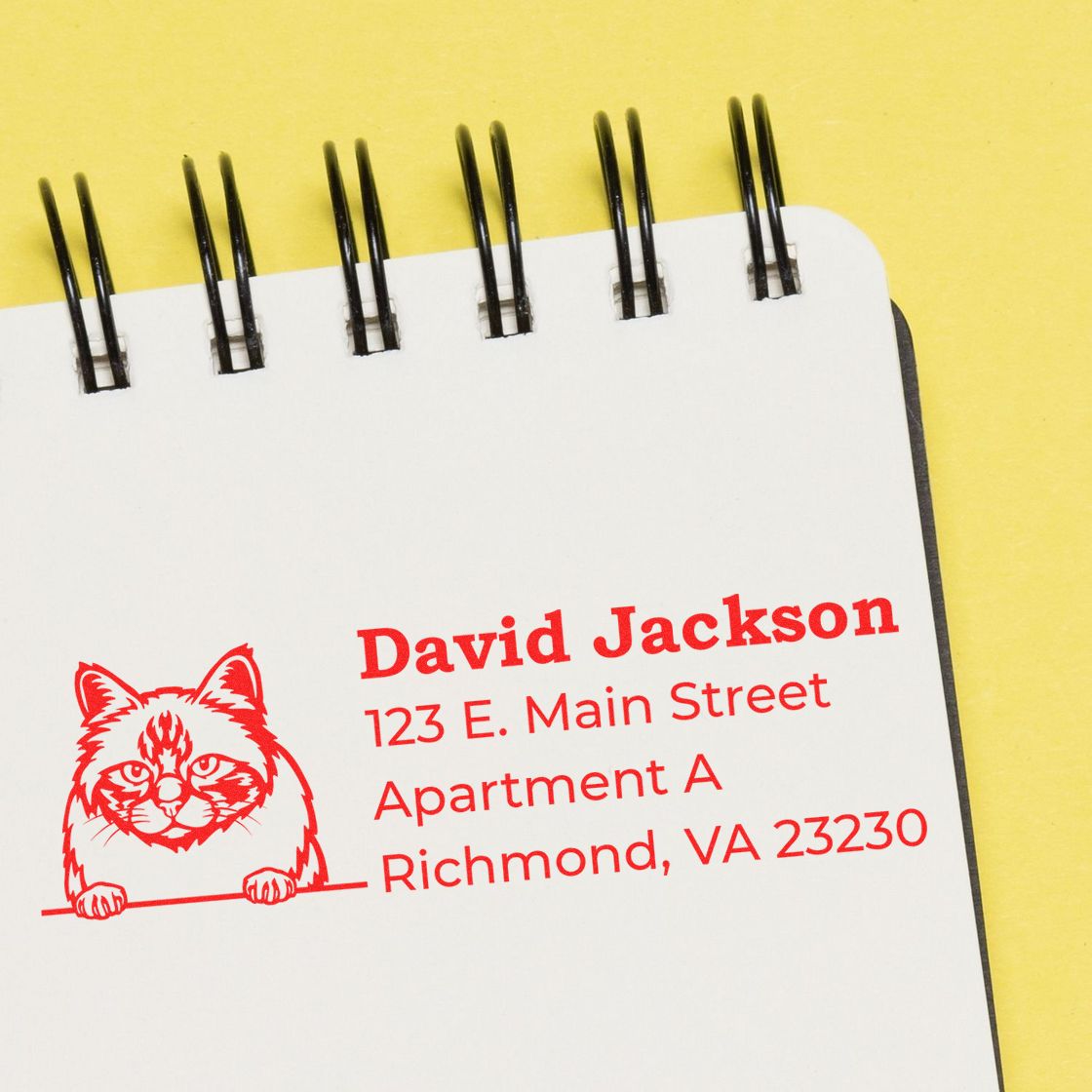 Self-Inking Birman Custom Address Stamp on a notepad, featuring a red cat design and sample address text in bold red font on a yellow background.