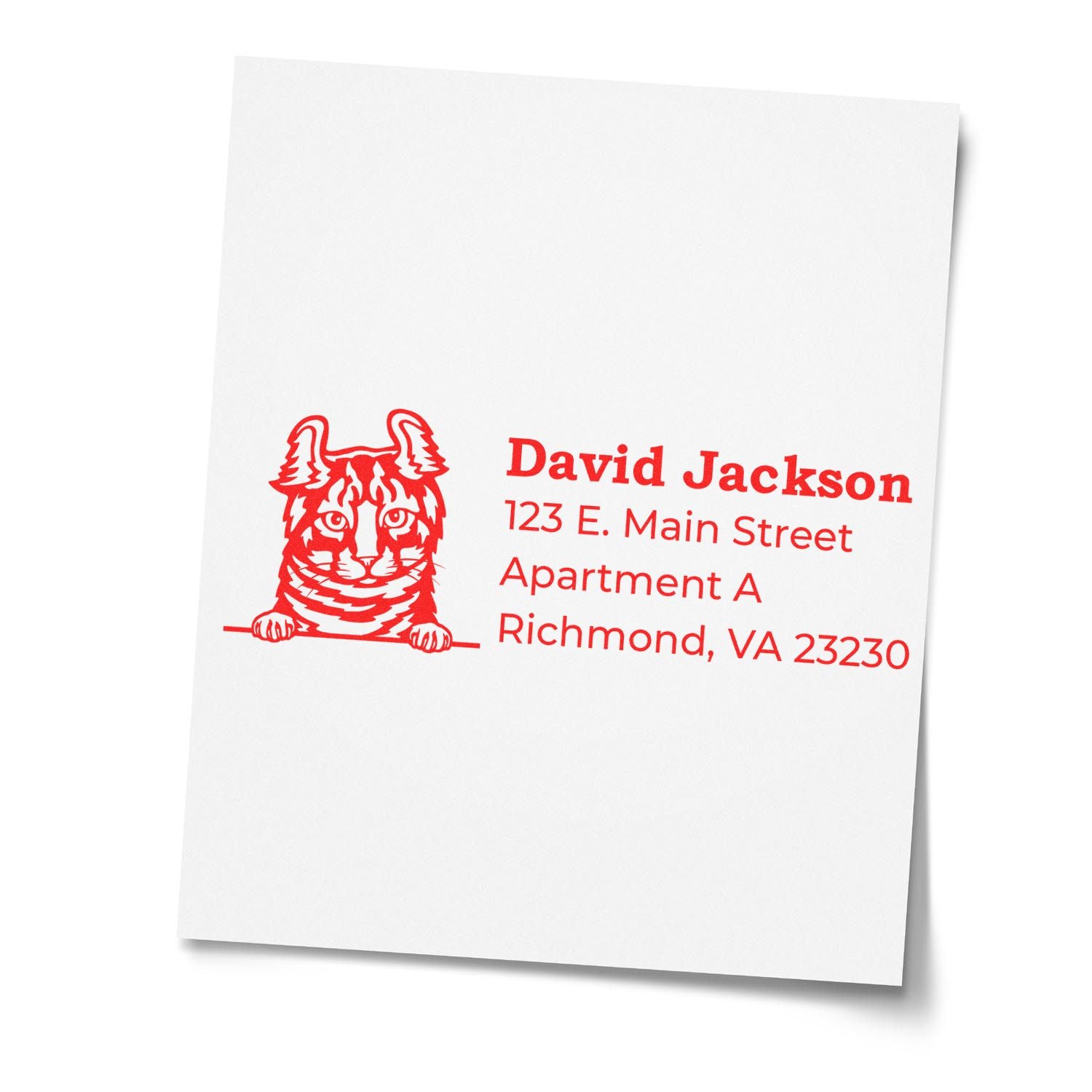 Red ink impression of the Self-Inking Highlander Custom Address Stamp featuring a cat illustration and sample address details on white paper.