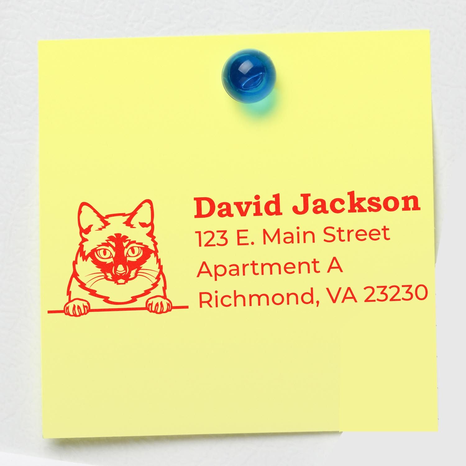 Yellow note with a red Mekong Bobtail cat design and address details, stamped using the Wood Handle Mekong Bobtail Cat Address Stamp, pinned with a blue magnet.