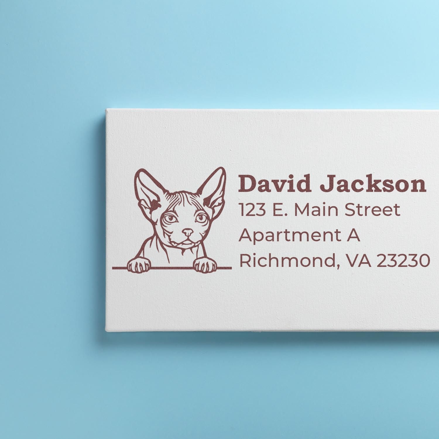 Wood Handle Minskin Cat Address Stamp on a blue background, featuring a cute Minskin cat illustration and sample address text in brown ink.