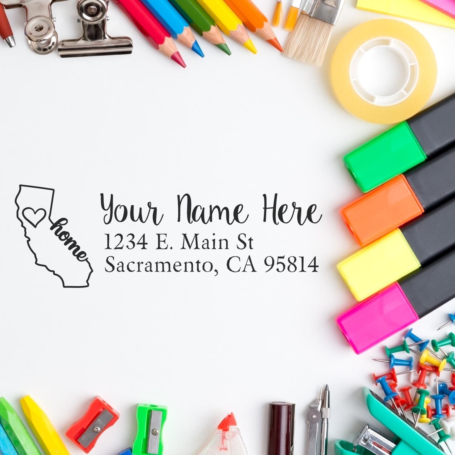 A Slim Pre-Inked California State Love Custom Address Stamp on white paper, surrounded by colorful office supplies like markers, pencils, and clips.