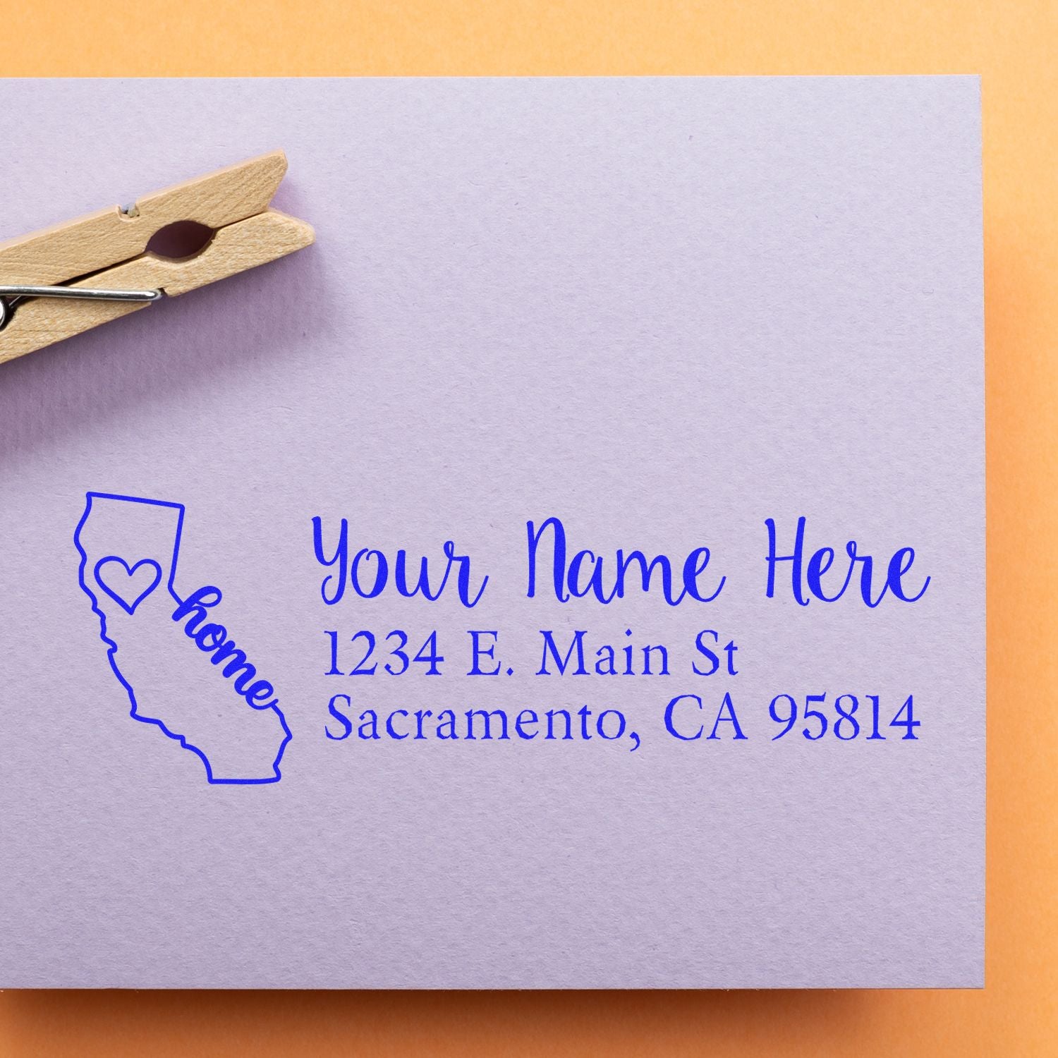 PSI Pre-Inked Personalized California State Love Address Stamp on a lavender envelope with a clothespin, featuring a heart and home text inside the California outline.