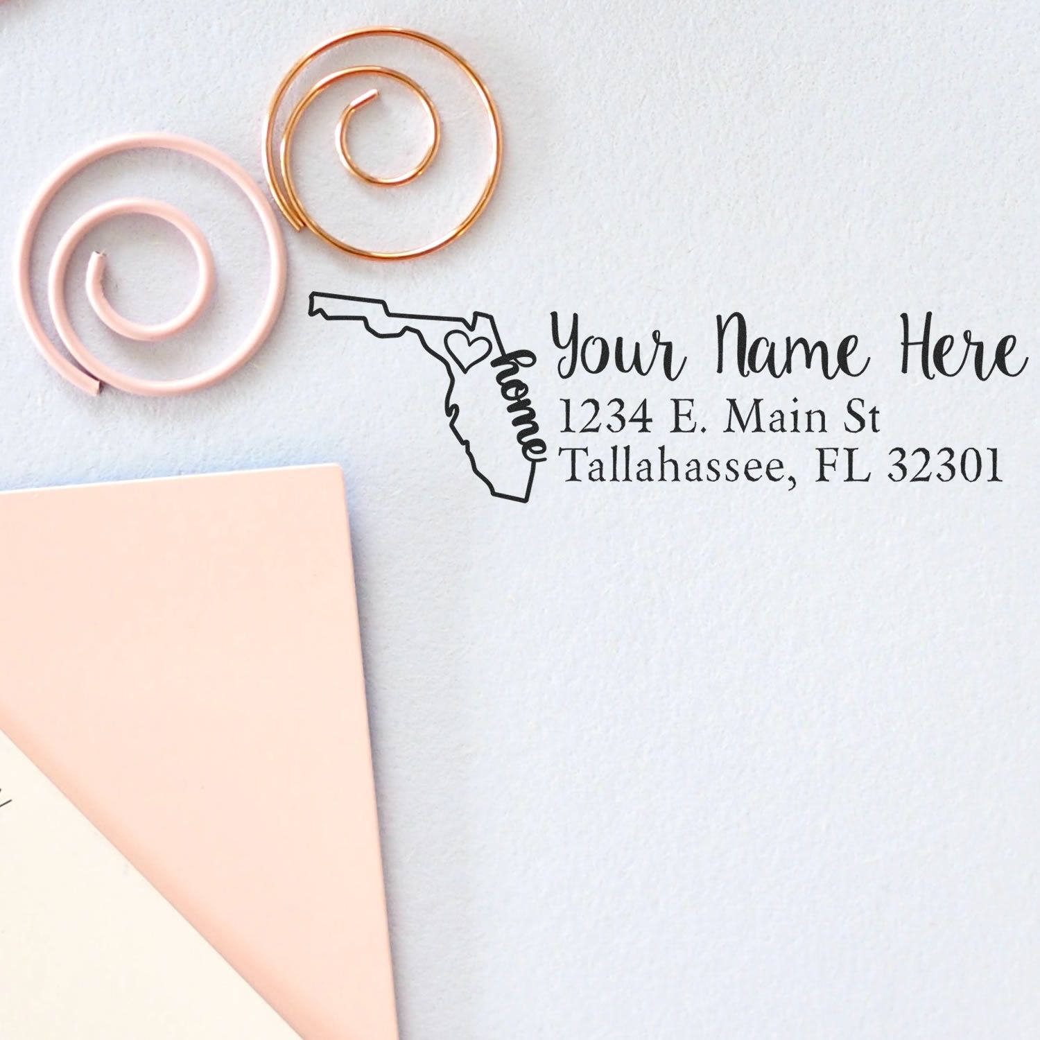 Slim Pre-Inked Florida State Love Custom Address Stamp on a light surface with decorative spirals and paper, featuring a Florida outline and personalized address text.