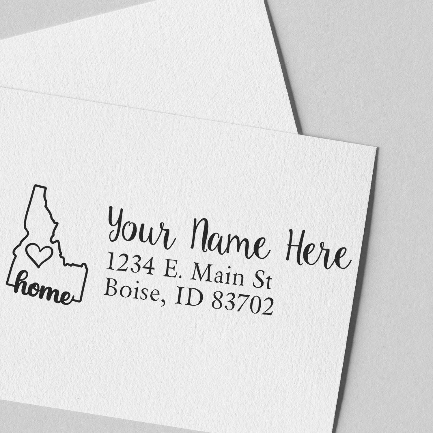 Idaho Self-Inking State Love Address Stamp on white paper, featuring a heart inside the Idaho state outline with home text, personalized with name and address in elegant script.