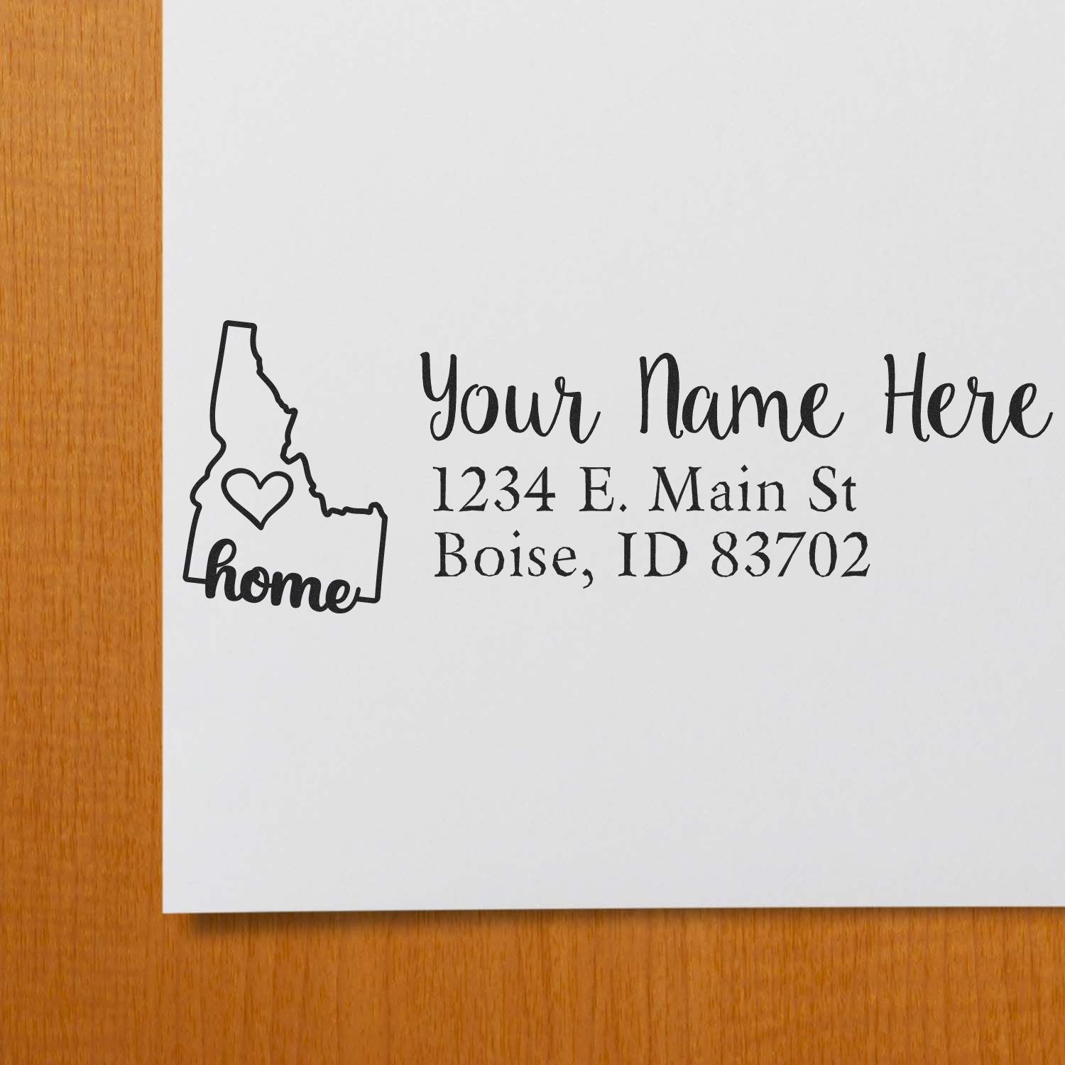 PSI Pre-Inked Personalized Idaho State Love Address Stamp on white paper, featuring a heart inside Idaho's outline and sample address text in elegant font.