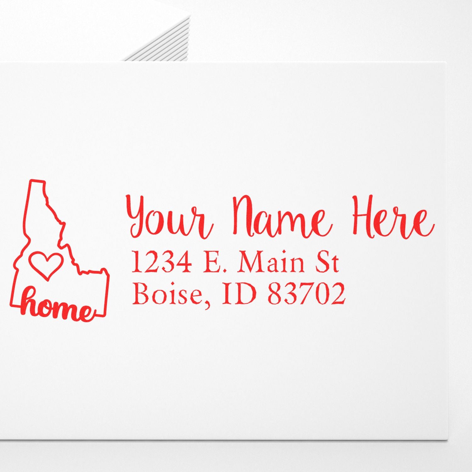 Idaho Self-Inking State Love Address Stamp on an envelope, featuring a red outline of Idaho with a heart and the word home, alongside customizable address text in a stylish font.