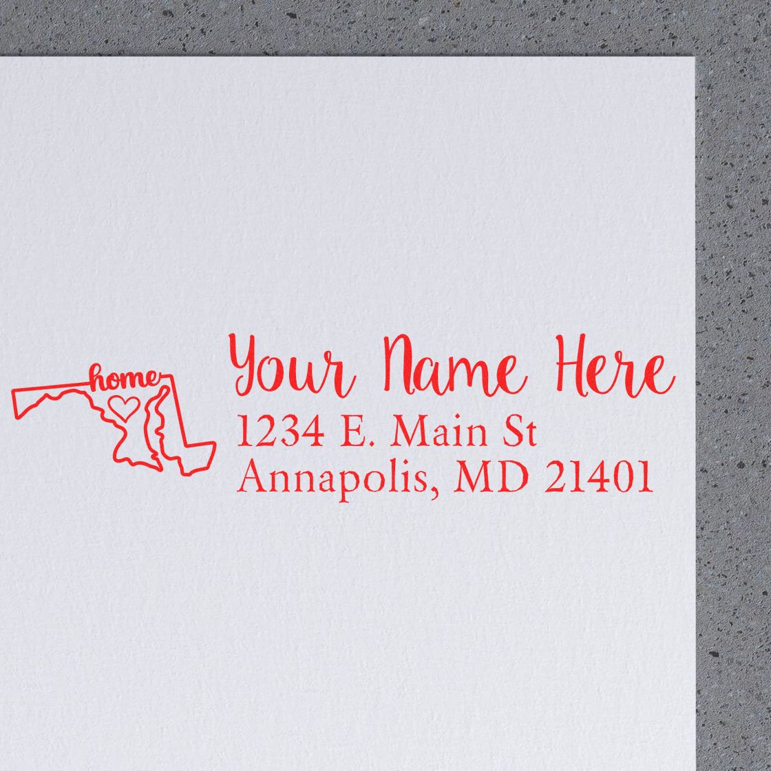 Maryland Self-Inking State Love Address Stamp on white paper, featuring a red outline of Maryland with home text and a heart, alongside customizable address details in red script.