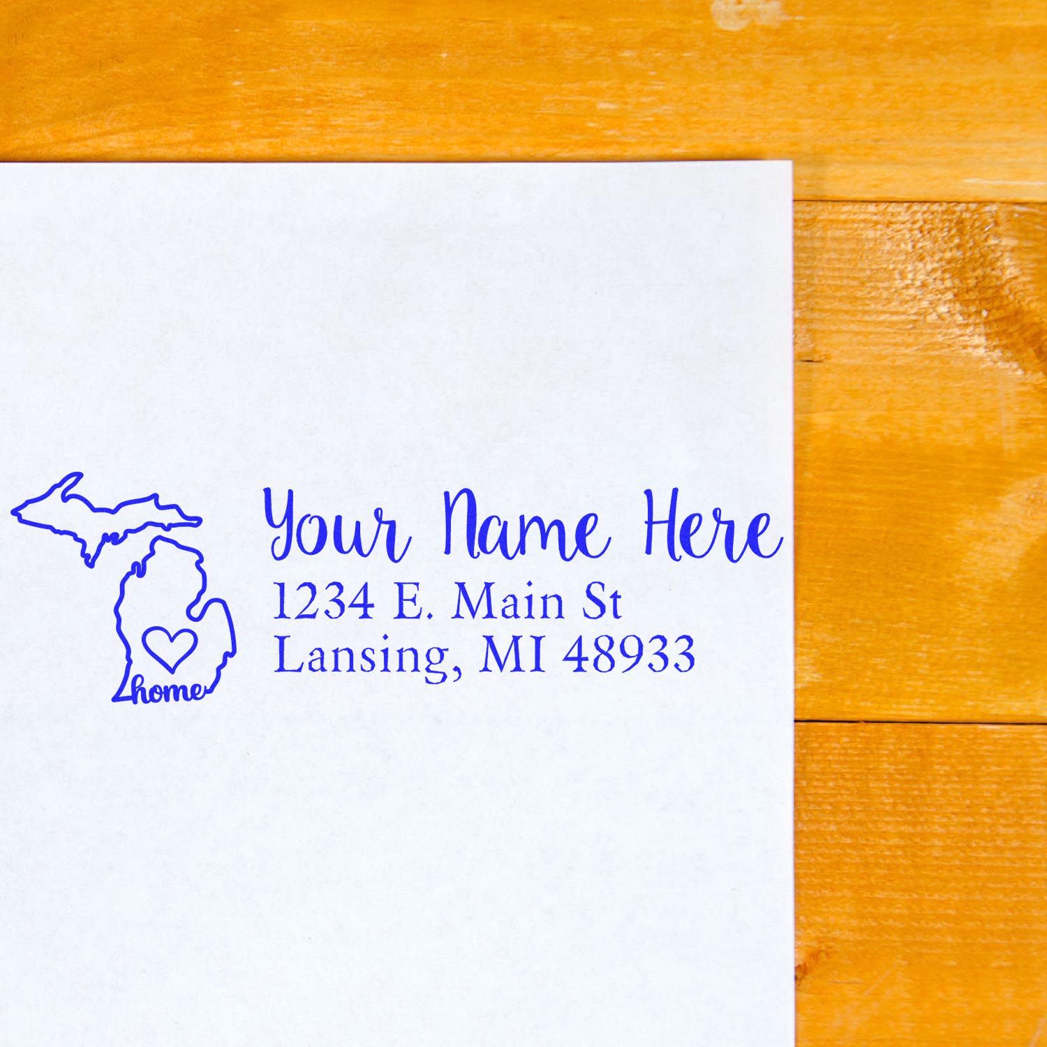 Michigan Self-Inking State Love Address Stamp on white paper, featuring a blue outline of Michigan with a heart and the word home, alongside customizable address text.