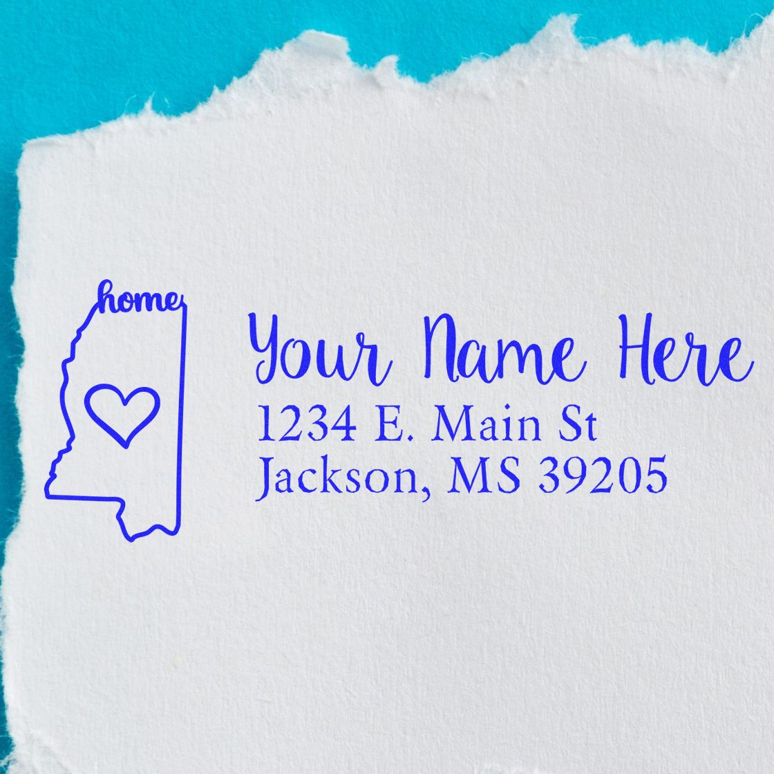 Wood Handle Mississippi Custom Address Rubber Stamp on torn paper, featuring a blue outline of Mississippi with a heart and customizable address text in elegant font.