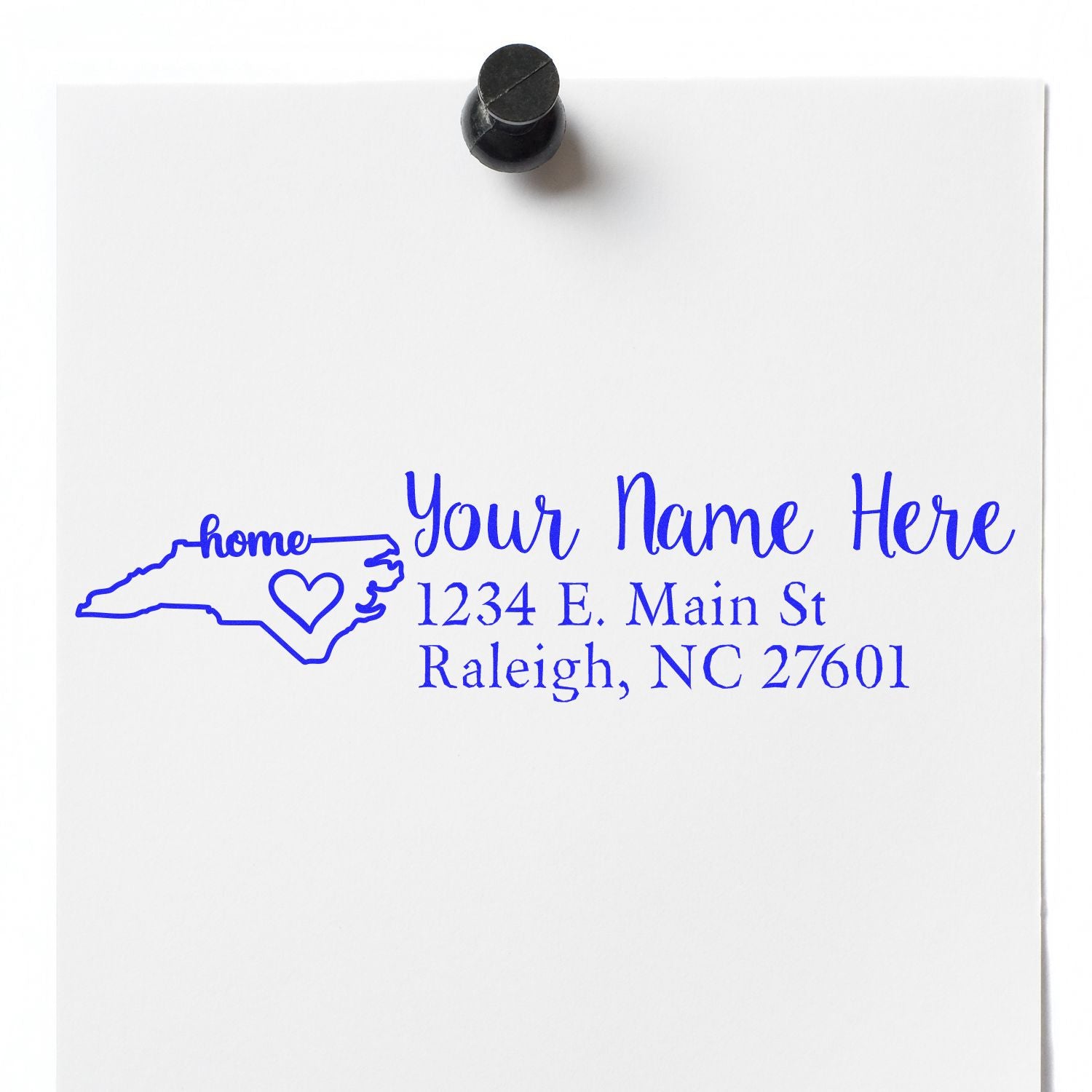 Slim Pre-Inked North Carolina State Love Custom Address Stamp on white paper, featuring a blue outline of NC with a heart and sample address text.