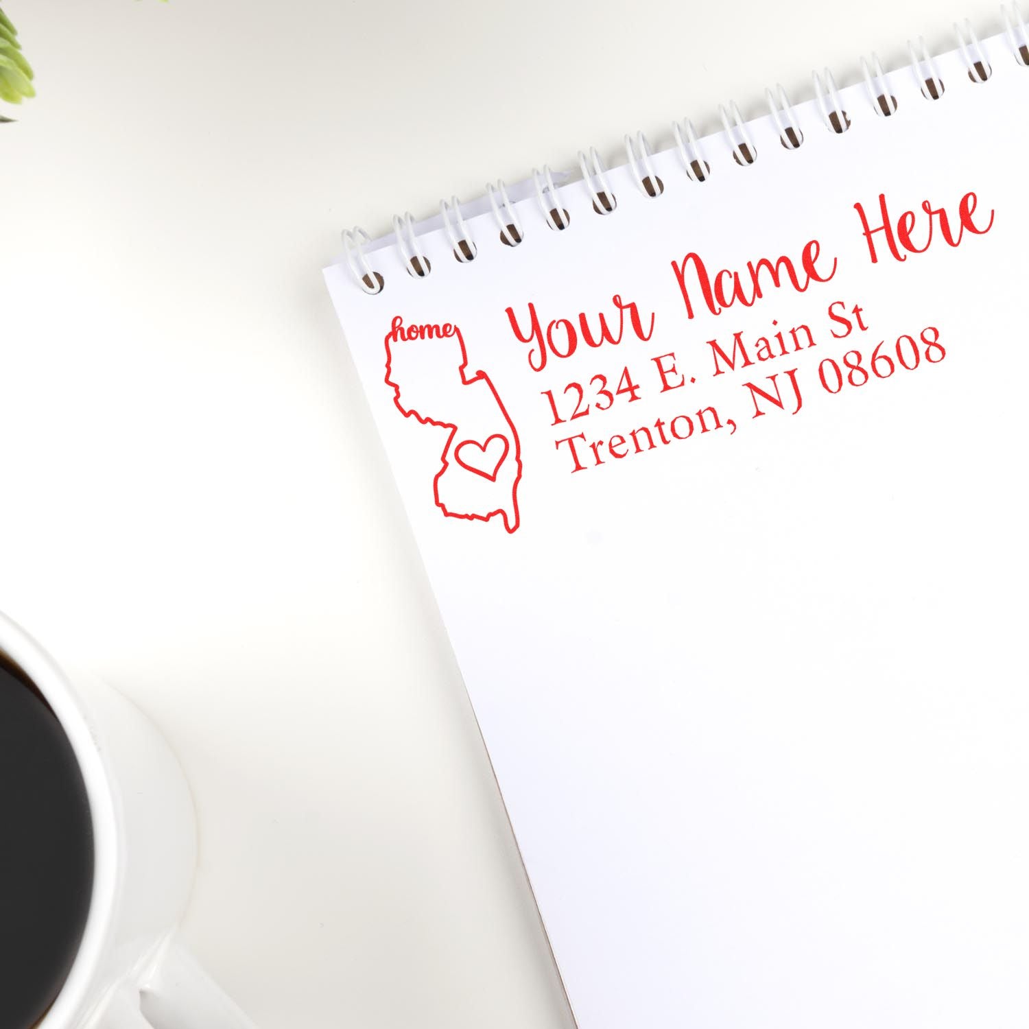 Wood Handle New Jersey Custom Address Rubber Stamp on a notepad, featuring a red outline of New Jersey with a heart, personalized address, and a coffee cup nearby.