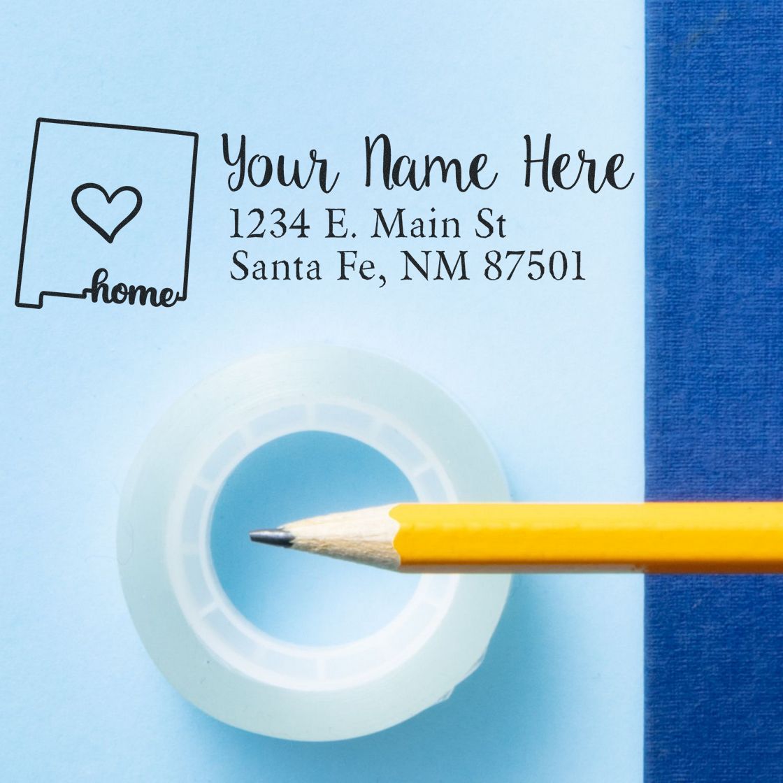 PSI Pre-Inked Personalized New Mexico State Love Address Stamp on blue paper with a pencil and tape, featuring a heart design and customizable address text.