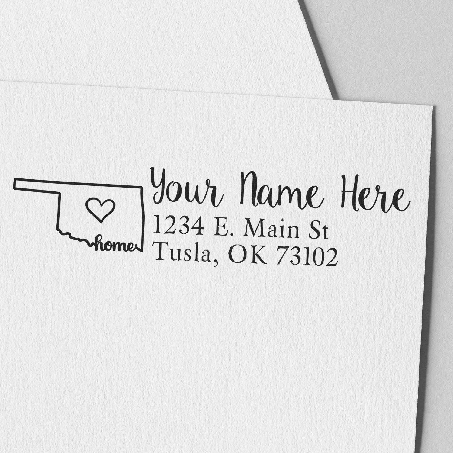 Slim Pre-Inked Oklahoma State Love Custom Address Stamp on white paper, featuring a heart inside the state outline with home text, personalized with name and address in elegant script.